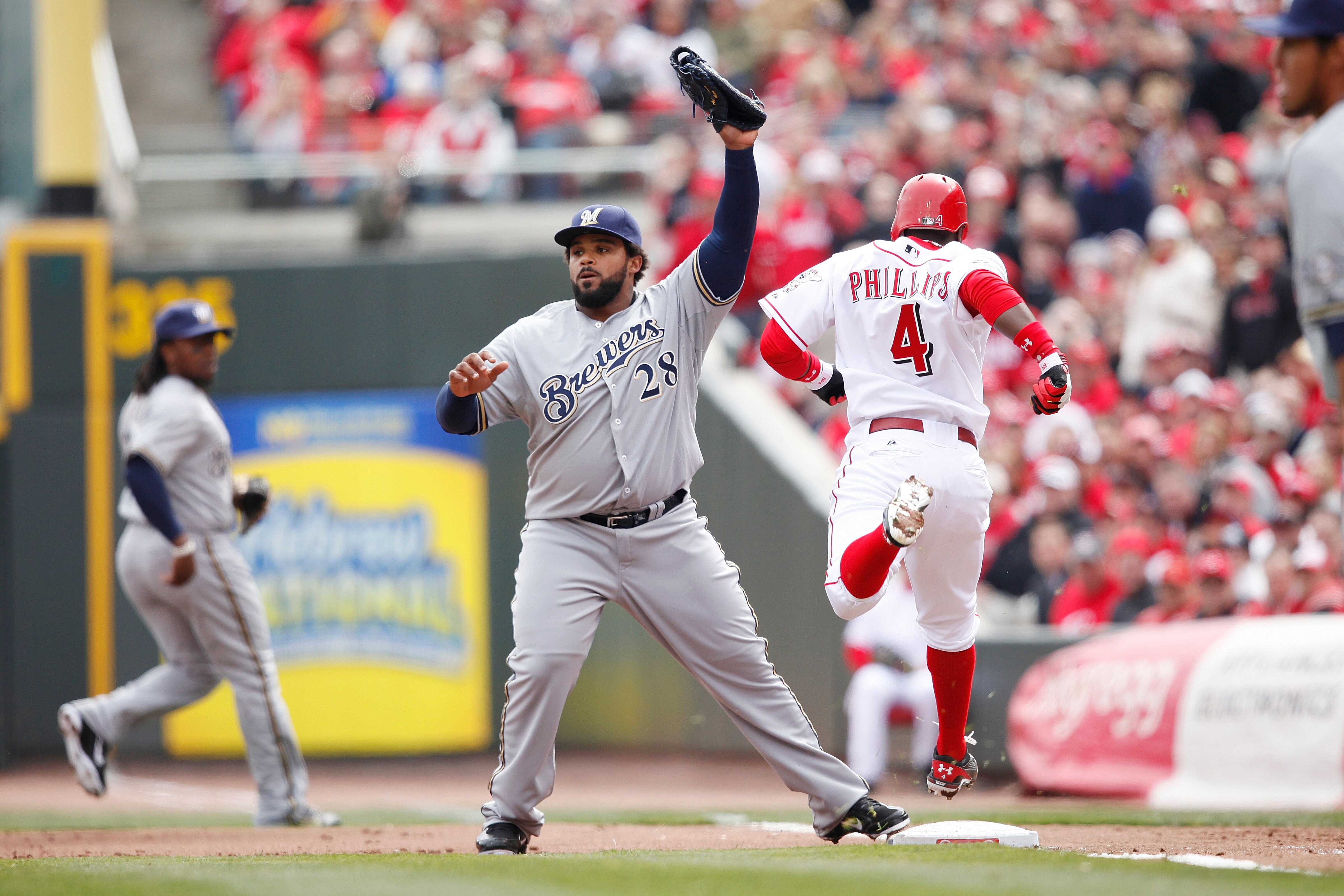 CINCINNATI, OH - MARCH 31: Prince Fielder #28 of the Milwaukee Brewers records an out against Brandon Phillips #4 of the Cincinnati Reds in the opening day game at Great American Ballpark on March 31, 2011 in Cincinnati, Ohio. The Reds won 7-6. (Photo by