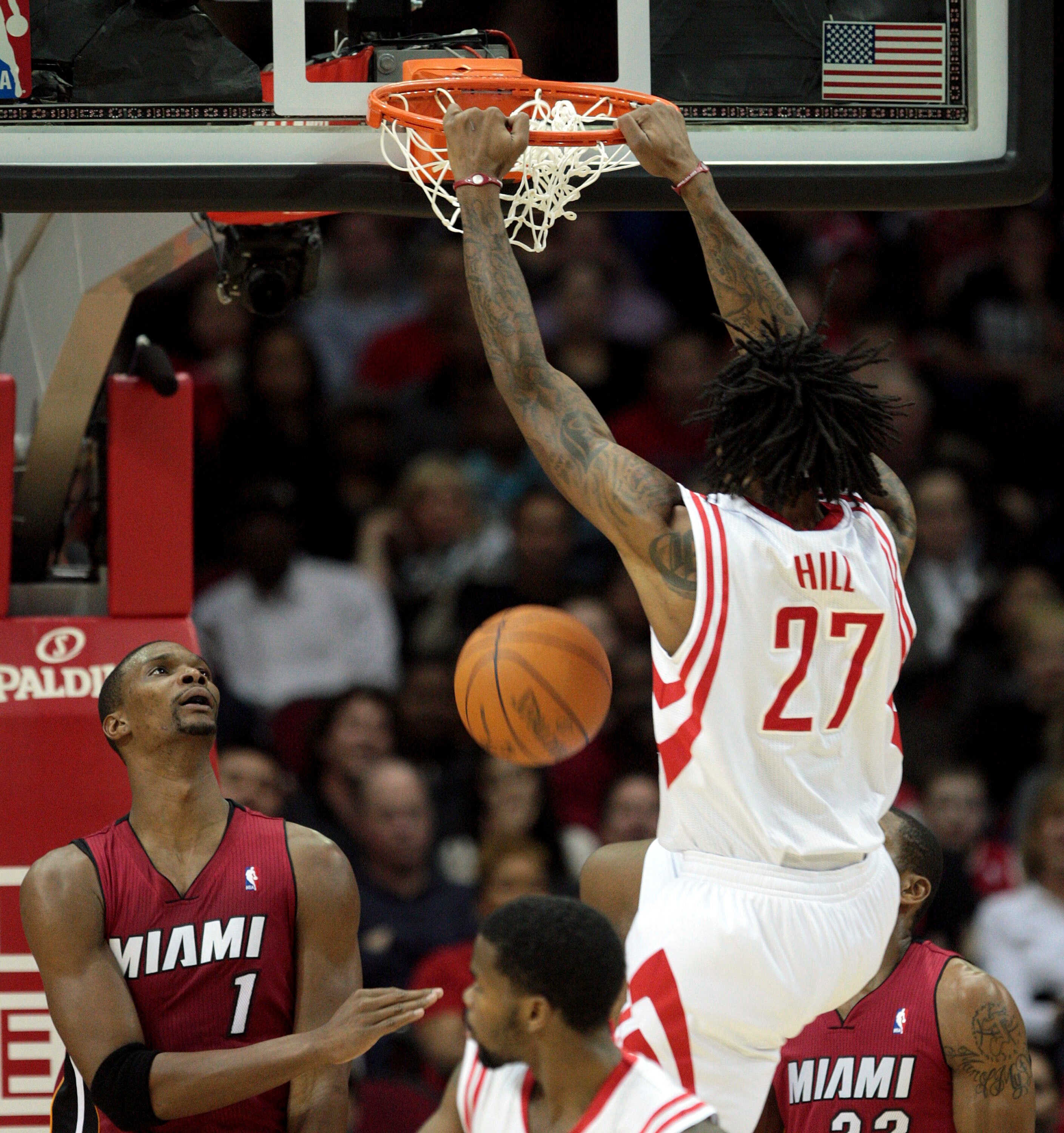 HOUSTON - DECEMBER 29:  Jordan Hill #27 of the Houston Rockets dunks over Chris  Bosh #1 of the Miami Heat in the first half at Toyota Center on December 29, 2010 in Houston, Texas.  NOTE TO USER: User expressly acknowledges and agrees that, by downloadin