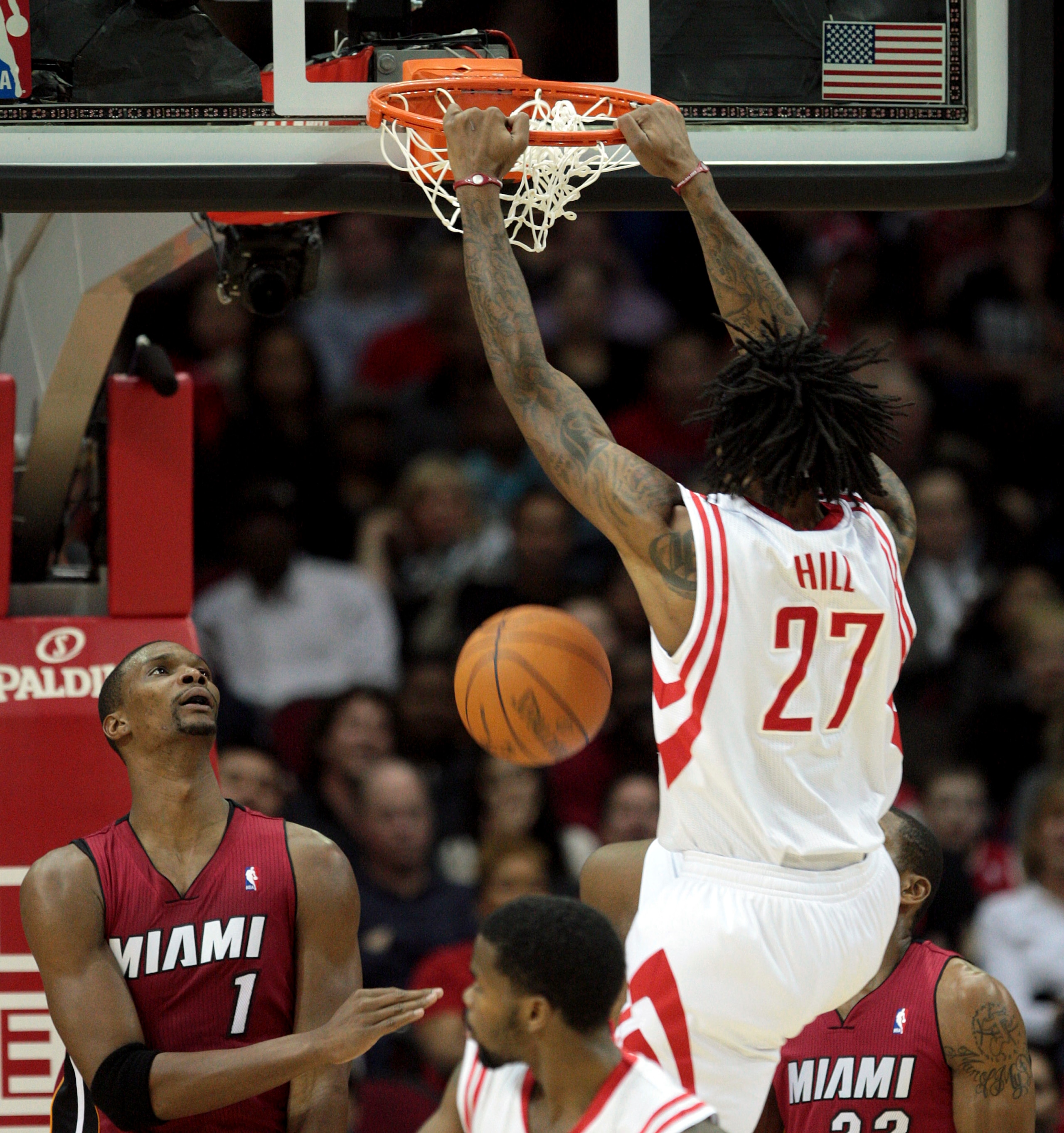 HOUSTON - DECEMBER 29:  Jordan Hill #27 of the Houston Rockets dunks over Chris  Bosh #1 of the Miami Heat in the first half at Toyota Center on December 29, 2010 in Houston, Texas.  NOTE TO USER: User expressly acknowledges and agrees that, by downloadin