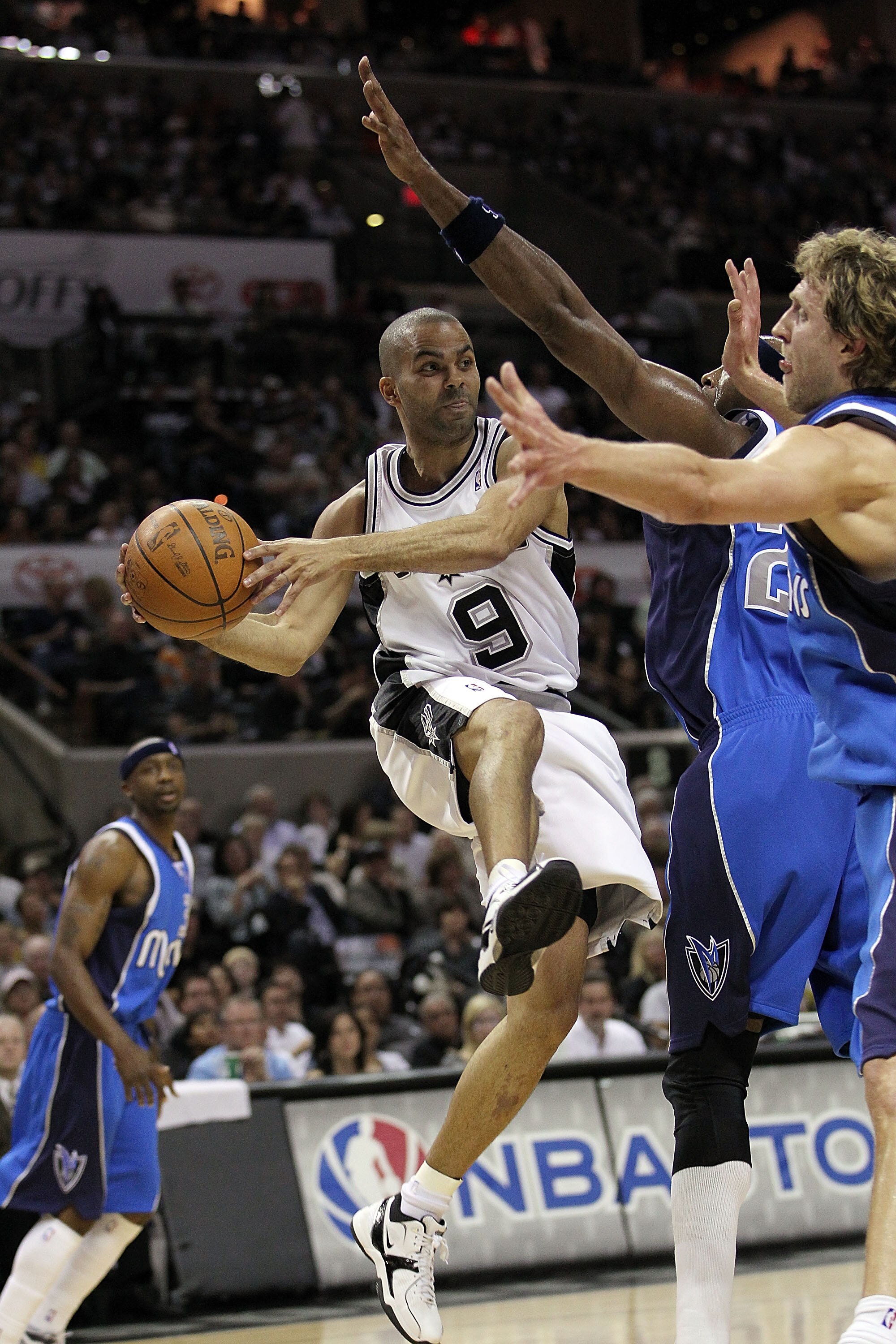 SAN ANTONIO - APRIL 23:  Guard Tony Parker #9 of the San Antonio Spurs passes the ball against Dirk Nowitzki #41 of the Dallas Mavericks in Game Three of the Western Conference Quarterfinals during the 2010 NBA Playoffs at AT&T Center on April 23, 2010 in
