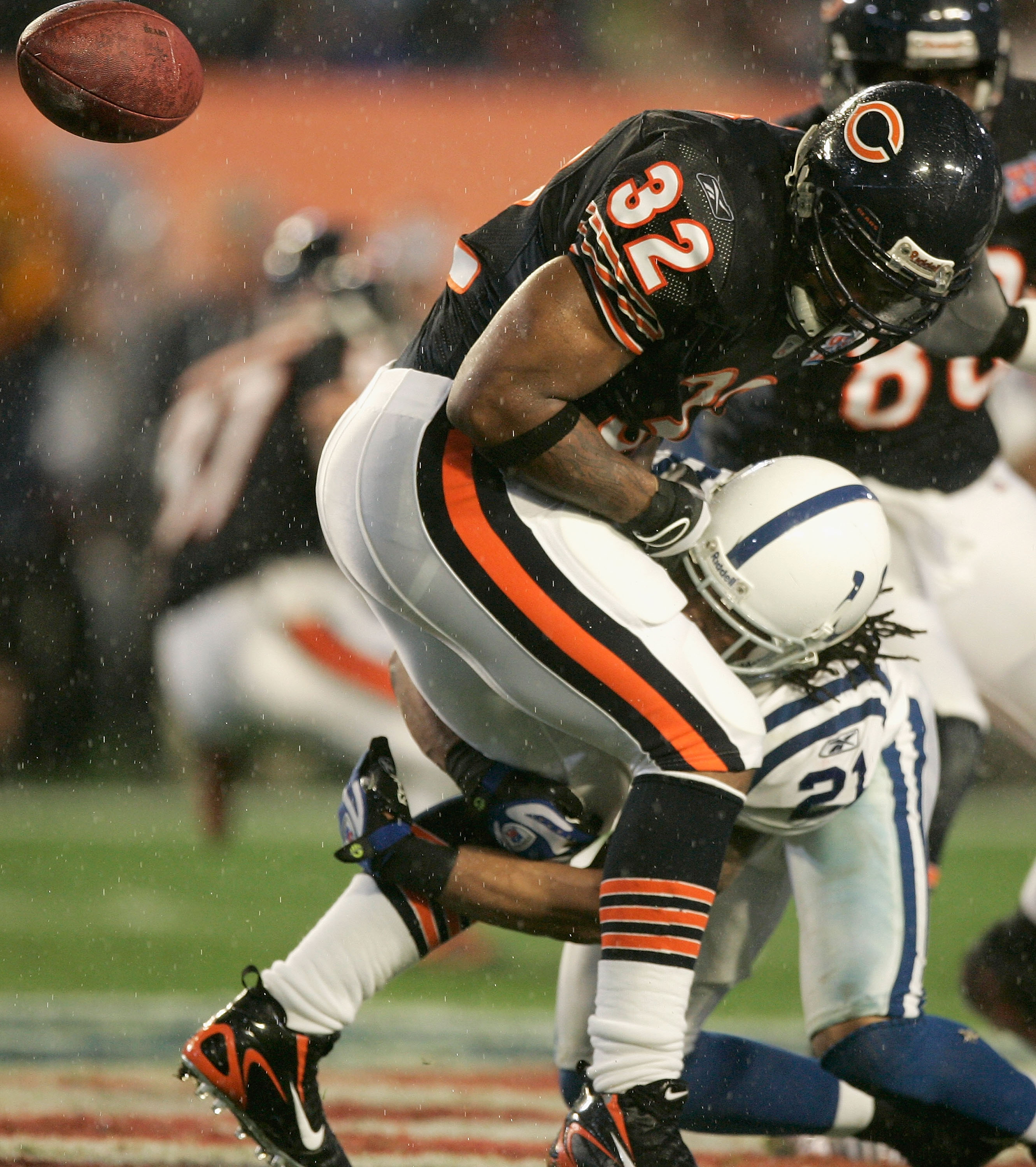 MIAMI GARDENS, FL - FEBRUARY 04:  Cedric Benson #32 of the Chicago Bears fumbles the ball after being tackled by Bob Sanders #21 of the Indianapolis Colts in the first quarter of Super Bowl XLI on February 4, 2007 at Dolphin Stadium in Miami Gardens, Flor