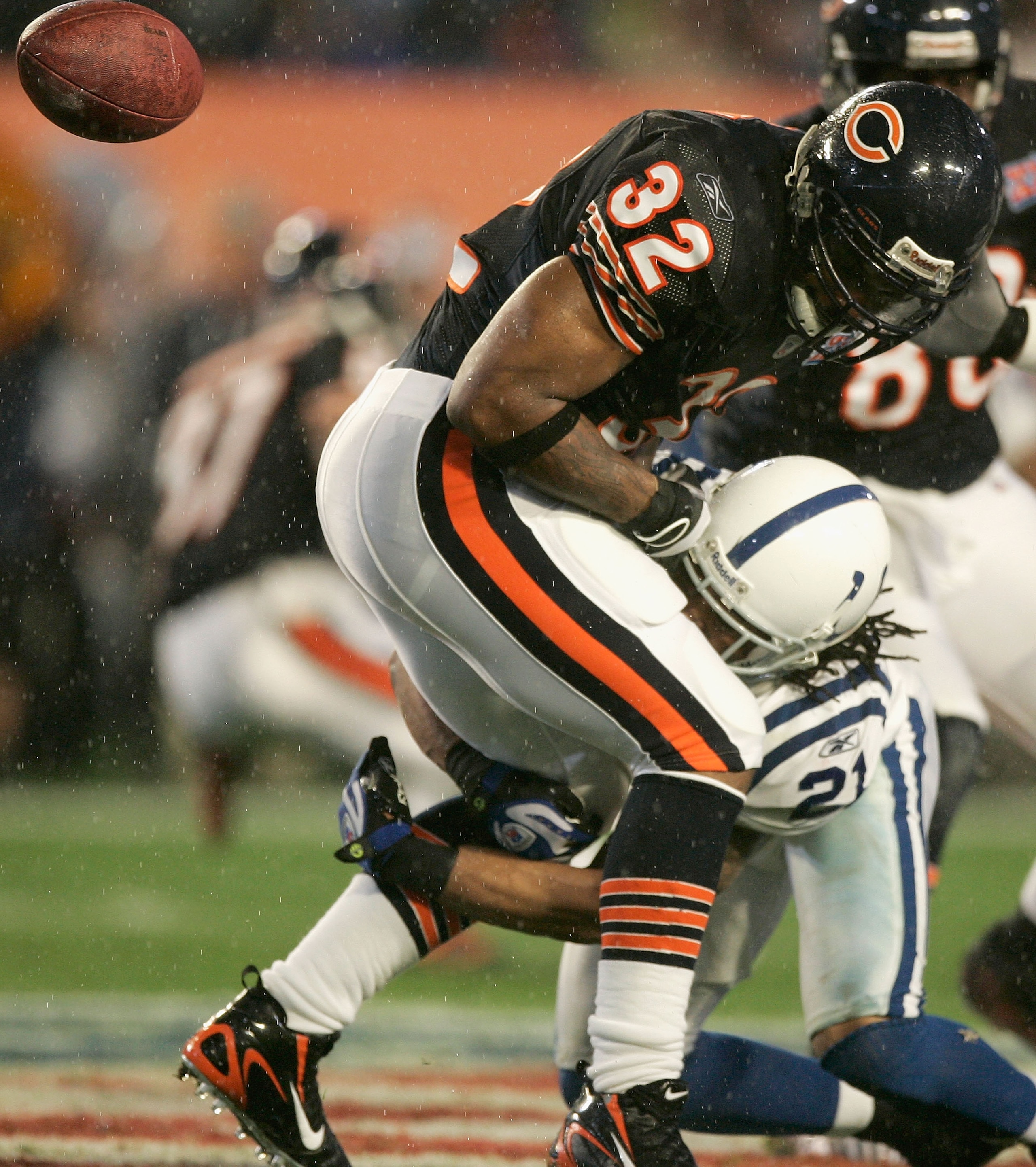 MIAMI GARDENS, FL - FEBRUARY 04:  Cedric Benson #32 of the Chicago Bears fumbles the ball after being tackled by Bob Sanders #21 of the Indianapolis Colts in the first quarter of Super Bowl XLI on February 4, 2007 at Dolphin Stadium in Miami Gardens, Flor