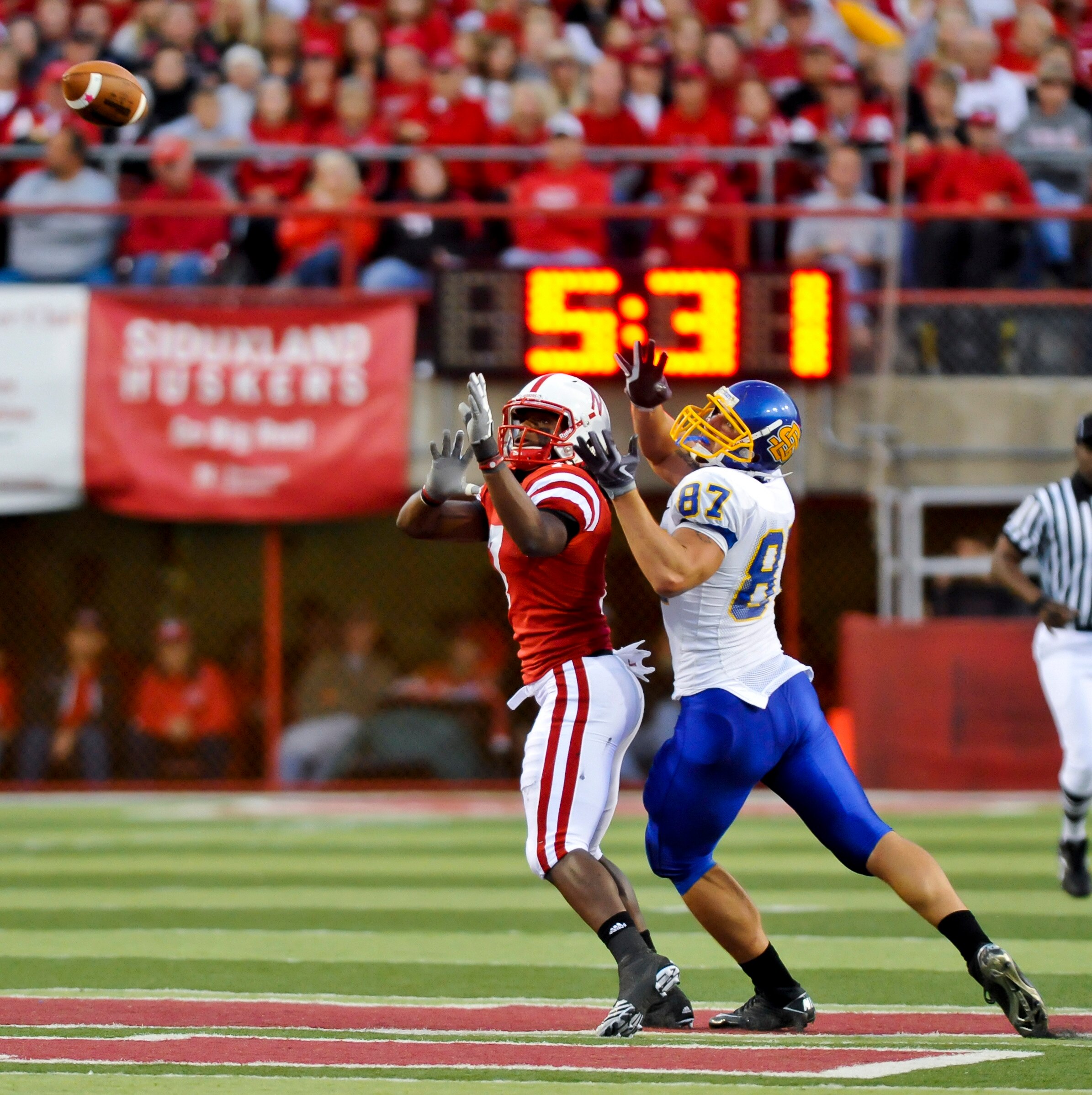 LINCOLN, NEBRASKA - SEPTEMBER 25: Nebraska Cornhuskers defensive back DeJon Gomes #7 and South Dakota State Jackrabbits tight end Colin Cochart #87 fight for position on the ball their game at Memorial Stadium on September 25, 2010 in Lincoln, Nebraska. N