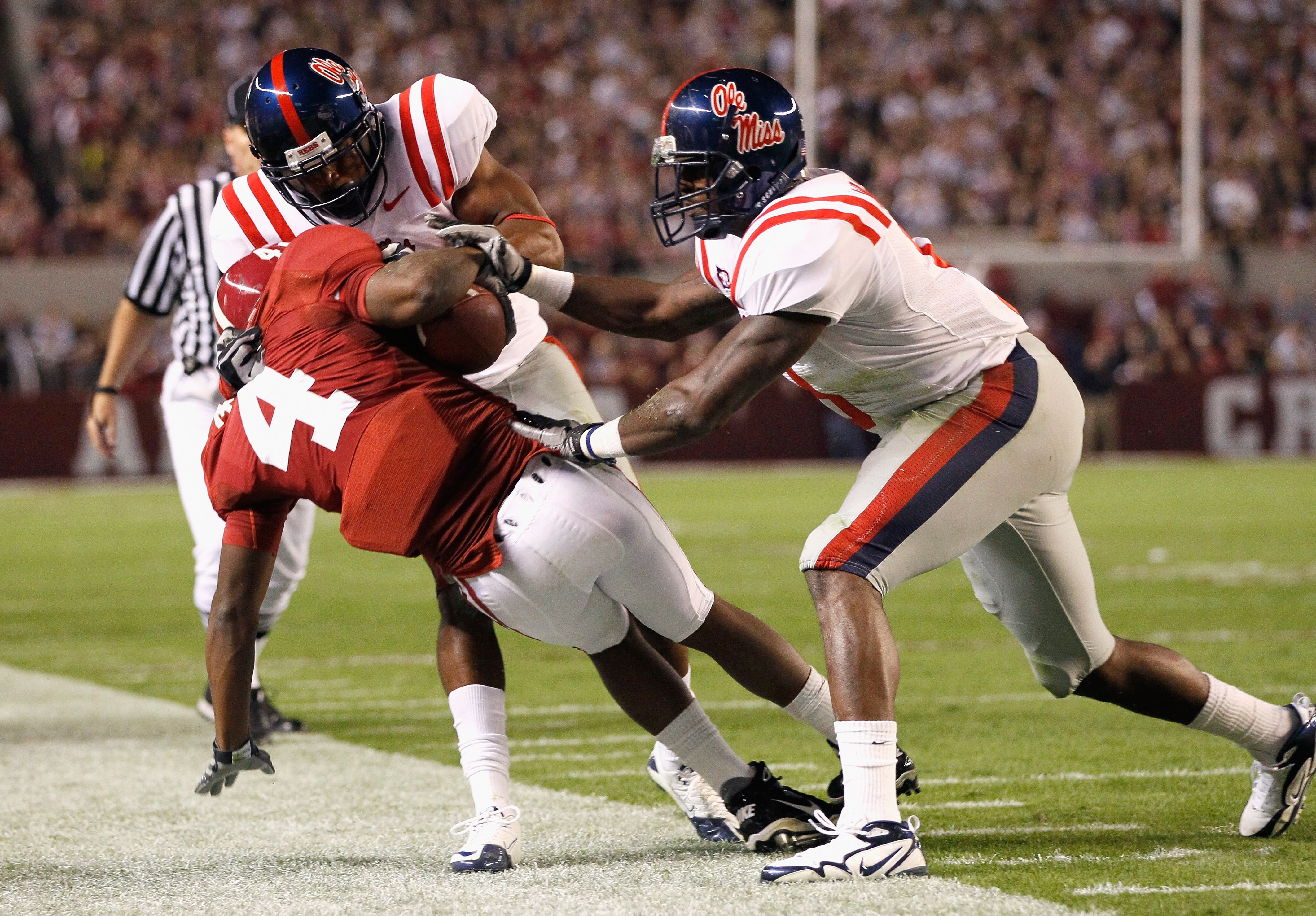 TUSCALOOSA, AL - OCTOBER 16:  Marquis Maze #4 of the Alabama Crimson Tide is tackled by Marcus Temple #4 and Allen Walker #9 of the Ole Miss Rebels at Bryant-Denny Stadium on October 16, 2010 in Tuscaloosa, Alabama.  (Photo by Kevin C. Cox/Getty Images)