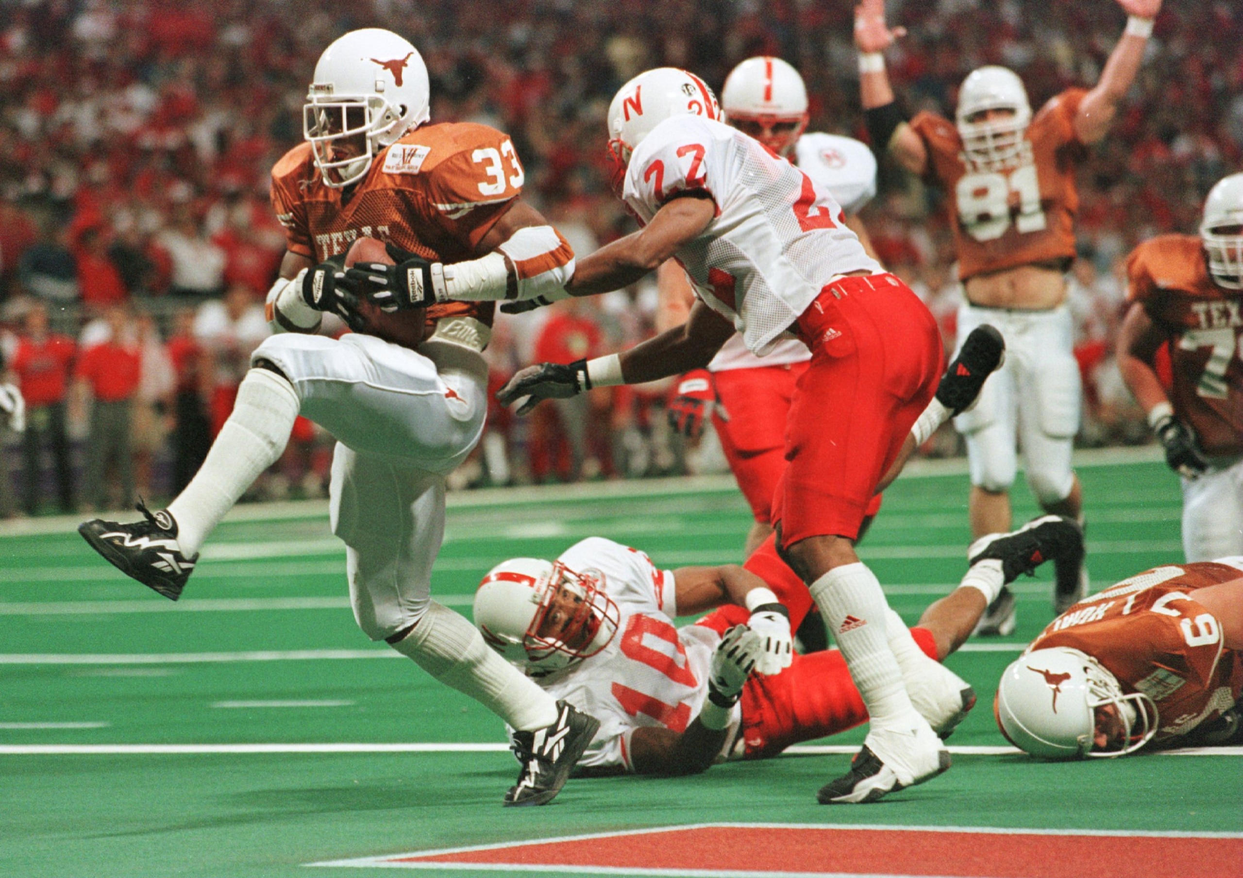 7 Dec 1996:  Running Back Priest Holmes #33 of the University of Texas Longhorns high steps into the end-zone past Ralph Brown #22 and Mike Minter #10 of the University of Nebraska Cornhuskers for the Longhorns first touchdown during the inaugural Big 12