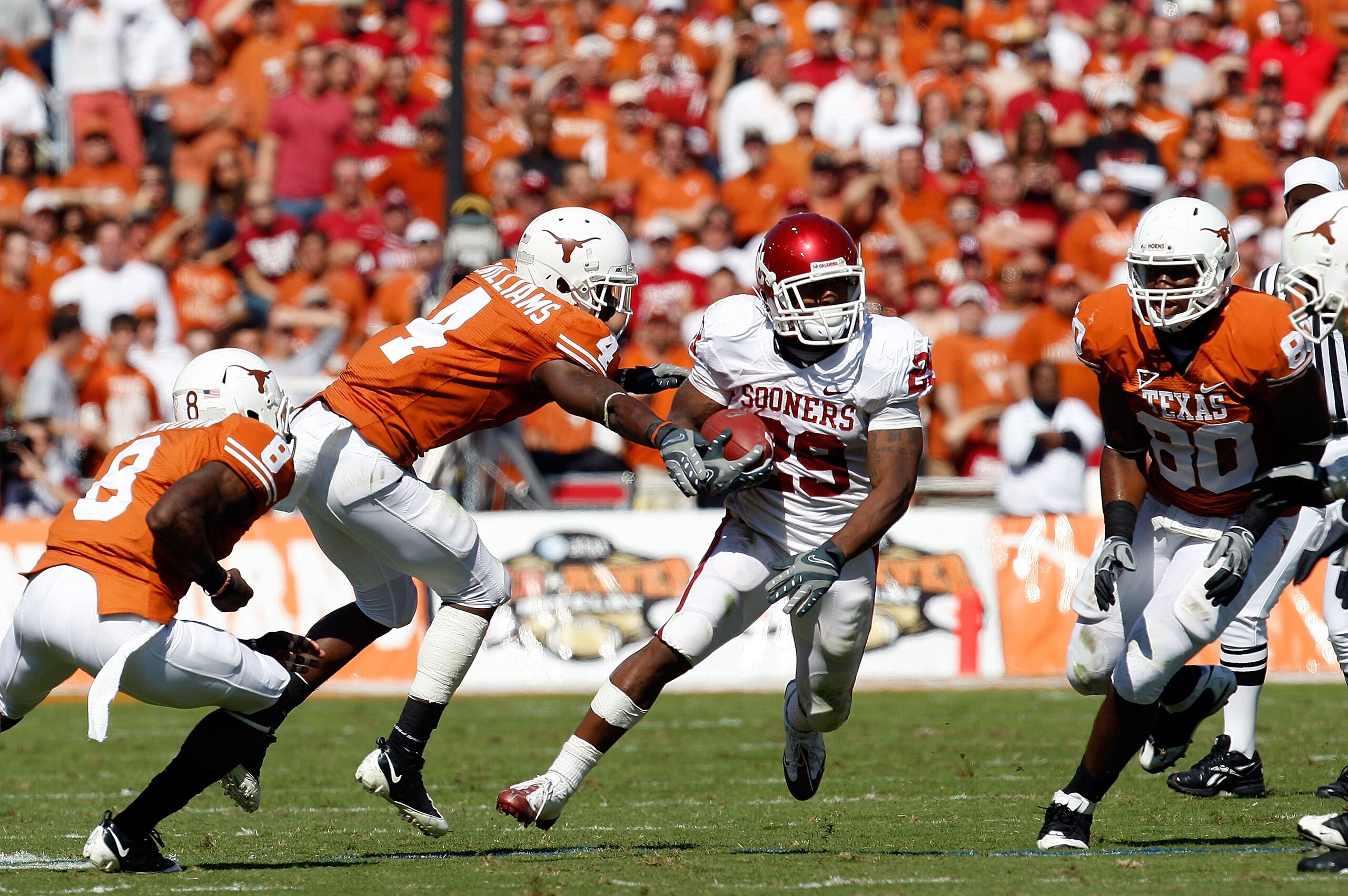 DALLAS - OCTOBER 17:  Running back Chris Brown #29 of the Oklahoma Sooners runs the ball past Aaron Williams #4 of the Texas Longhorns at Cotton Bowl on October 17, 2009 in Dallas, Texas.  (Photo by Ronald Martinez/Getty Images)