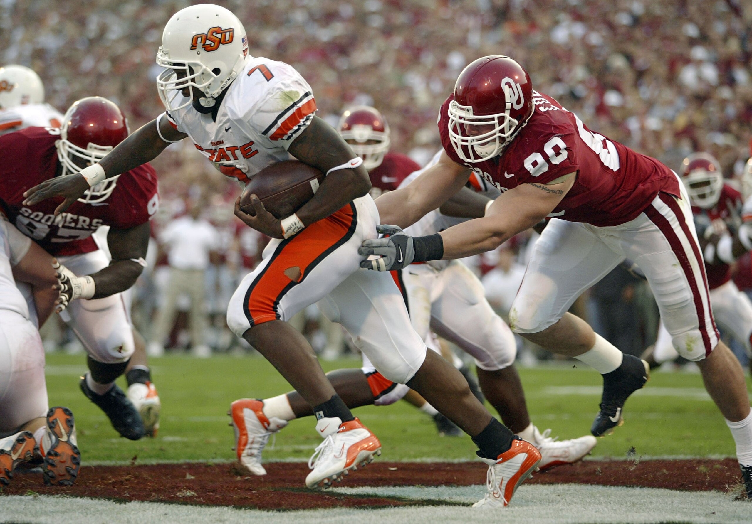 NORMAN, OK - NOVEMBER 1:  Defensive lineman Dan Cody #80 of the Oklahoma Sooners chases running back Tatum Bell #7 of the Oklahoma State Cowboys through the endzone but can't come up with a safety in the third quarter November 1, 2003 at Memorial Stadium