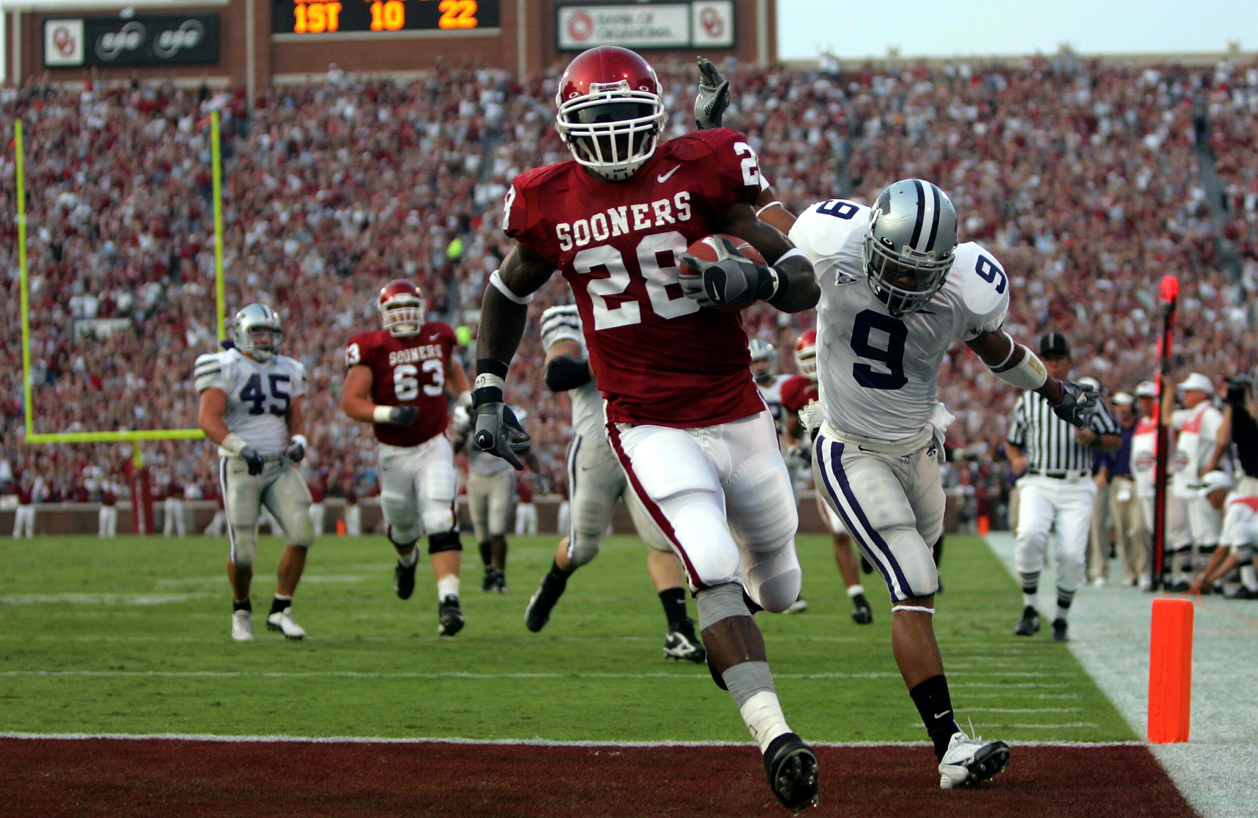 NORMAN, OK - OCTOBER 1:  Running back Adrian Peterson #28 of the Oklahoma Sooners runs for a touchdown past Kyle Williams #9 of the Kansas State Wildcats on October 1, 2005 at Memorial Stadium in Norman, Oklahoma.  (Photo by Ronald Martinez/Getty Images)