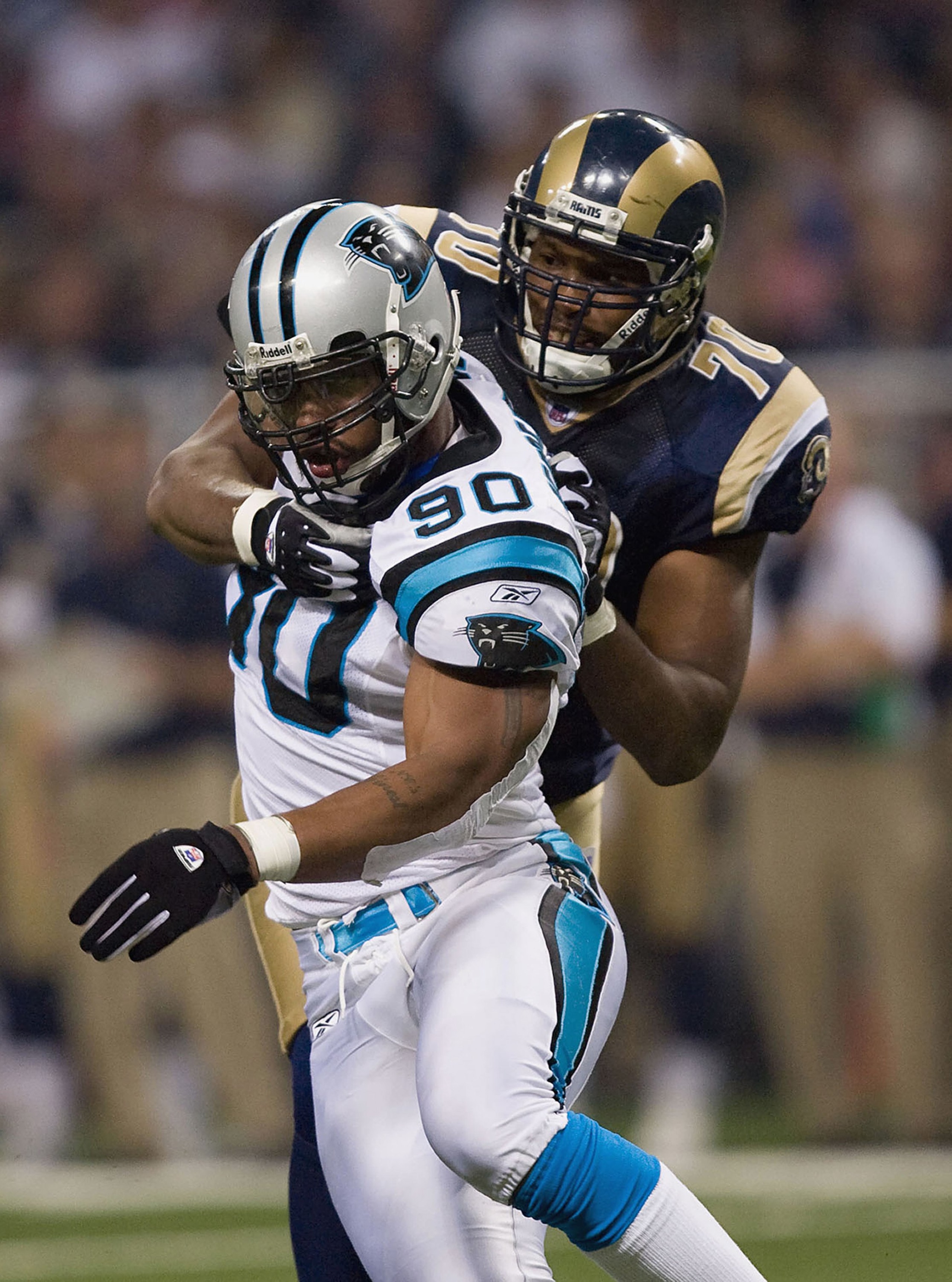 ST. LOUIS, MO - SEPTEMBER 9:  Julius Peppers #90 of the Carolina Panthers is grabbed from behind by Alex Barron #70 of the St. Louis Rams during the NFL game on September 9, 2007 at the Edward Jones Dome in St. Louis, Missouri.  The Panthers beat the Rams