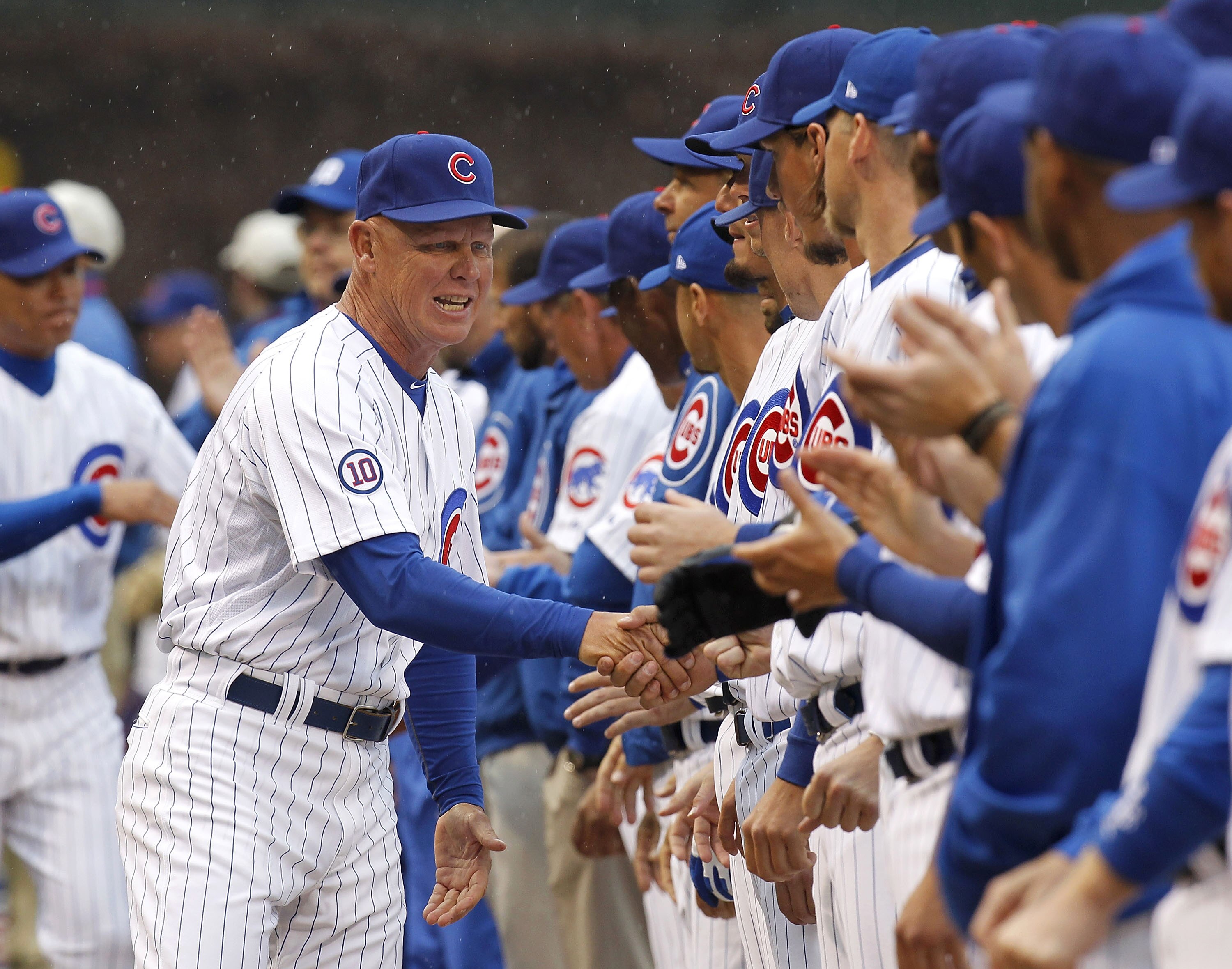CHICAGO, IL - APRIL 01:  Mike Quade Manager of the Chicago Cubs shakes hands with his players during introductions prior to playing the Pittsburgh Pirates on opening day at Wrigley Field on April 1, 2011 in Chicago, Illinois. Pittsburgh won the game 6-3.