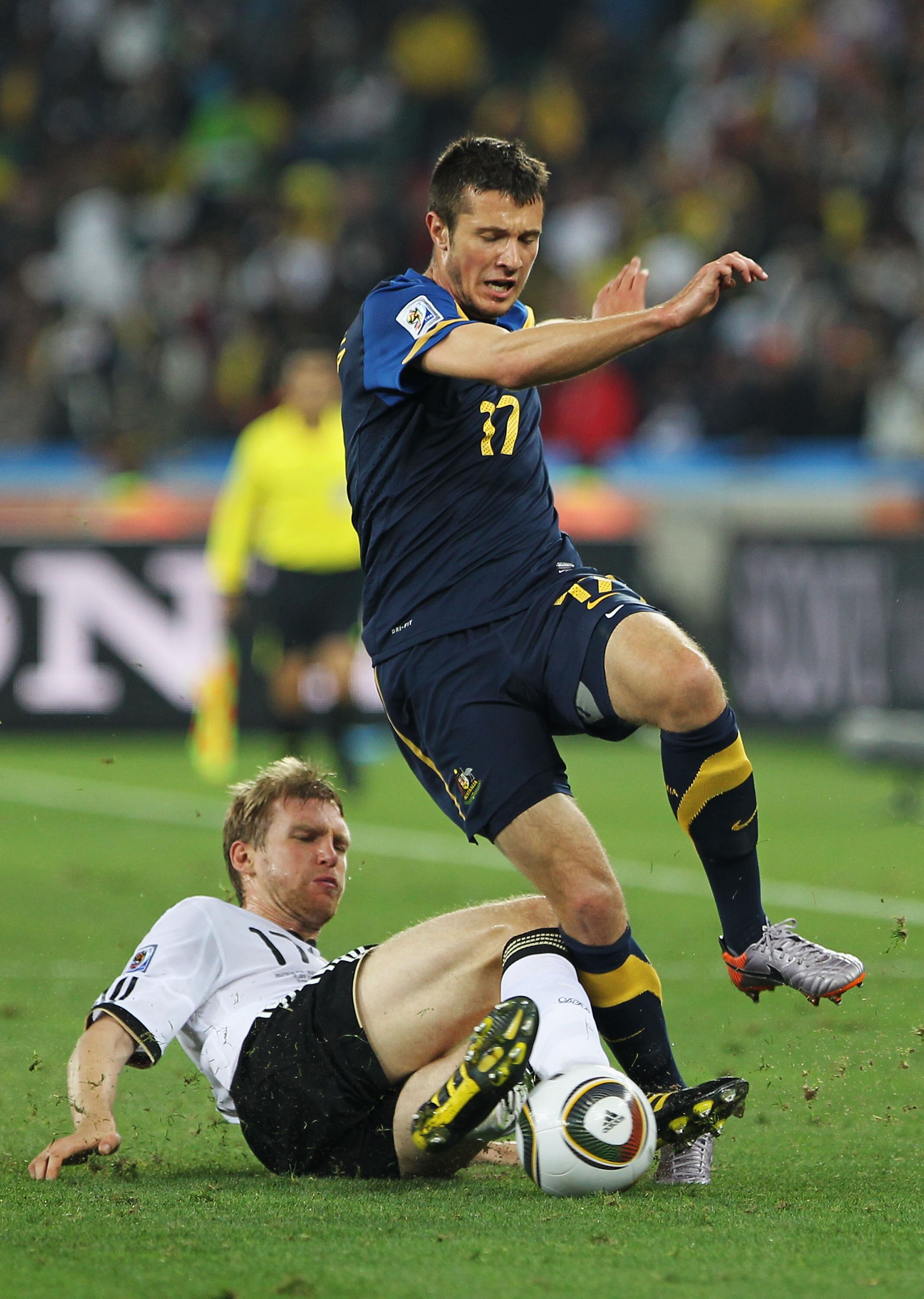 DURBAN, SOUTH AFRICA - JUNE 13:  Per Mertesacker of Germany tackles Nikita Rukavytsya of Australia during the 2010 FIFA World Cup South Africa Group D match between Germany and Australia at Durban Stadium on June 13, 2010 in Durban, South Africa.  (Photo