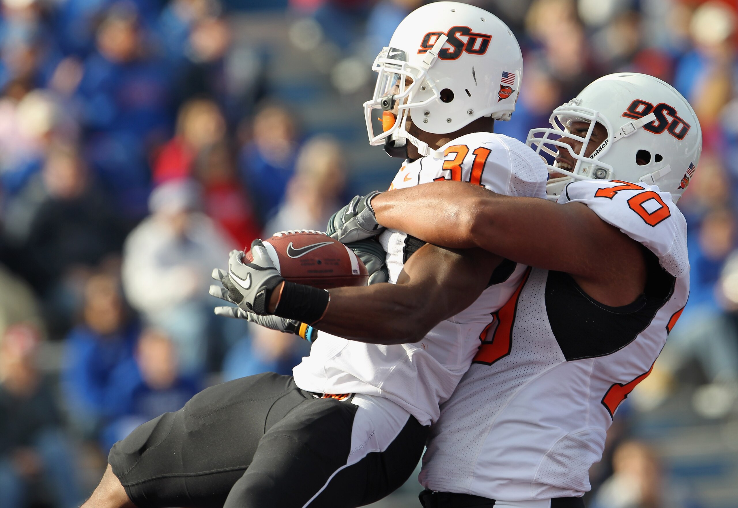 LAWRENCE, KS - NOVEMBER 20: Jeremy Smith #31 of the Oklahoma State Cowboys is congratulated by Jonathan Rush #70 after a touchdown during the game against the Kansas Jayhawks on November 20, 2010 at Memorial Stadium in Lawrence, Kansas. (Photo by Jamie LAWRENCE, KS - NOVEMBER 20: Jeremy Smith #31 of the Oklahoma State Cowboys is congratulated by Jonathan Rush #70 after a touchdown during the game against the Kansas Jayhawks on November 20, 2010 at Memorial Stadium in Lawrence, Kansas. (Photo by Jamie