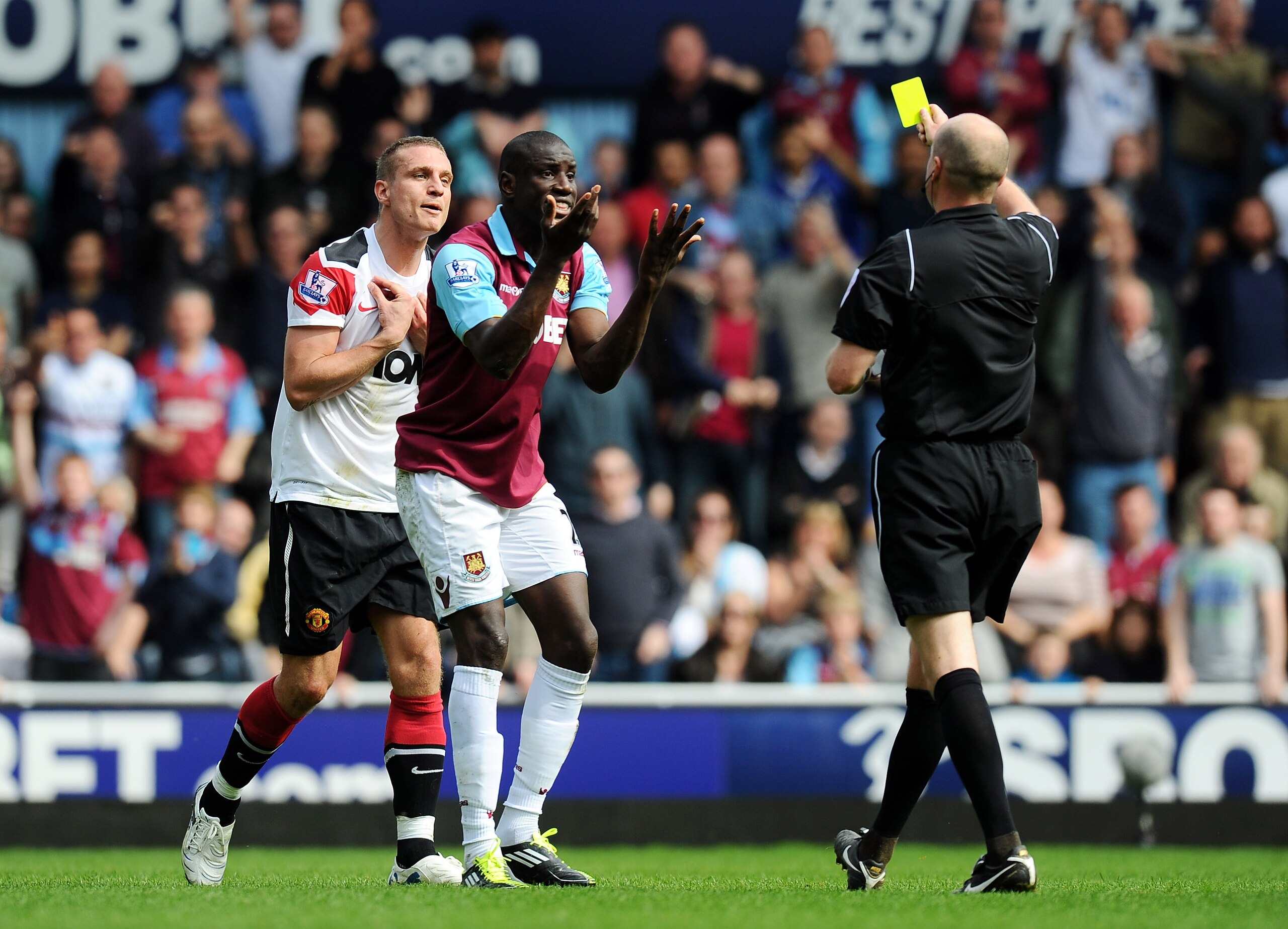 LONDON, ENGLAND - APRIL 02:  Nemanja Vidic of Manchester United is shown the yellow card by referee Lee Mason as Demba Ba of West Ham United gestures during the Barclays Premier League match between West Ham United and Manchester United at the Boleyn Grou