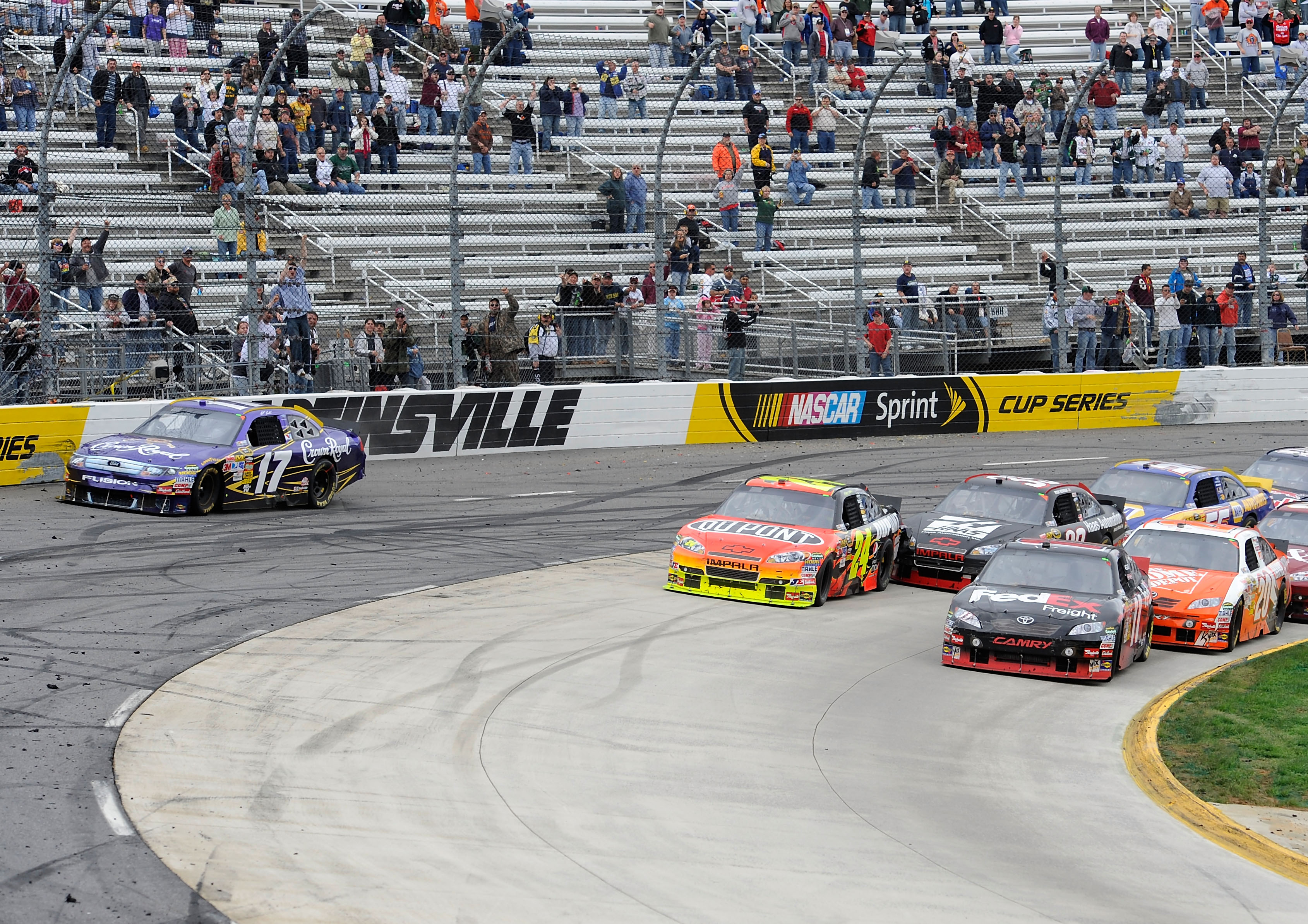 MARTINSVILLE, VA - MARCH 29:  Matt Kenseth, driver of the #17 Crown Royal Ford slides up the track as Jeff Gordon, driver of the #24 DuPont Chevrolet and Denny Hamlin, driver of the #11 FedEx Express Toyota, race for the lead during the NASCAR Sprint Cup
