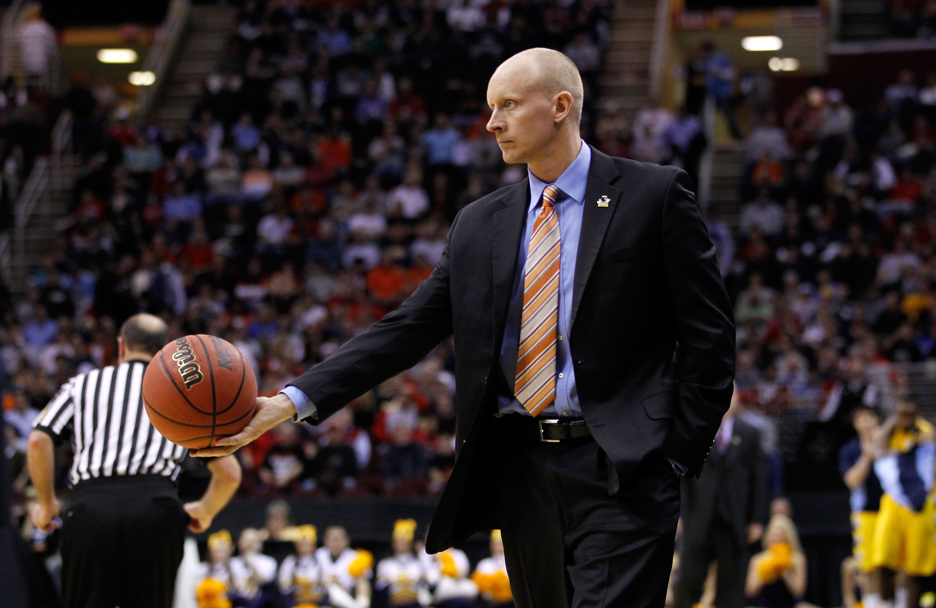 CLEVELAND, OH - MARCH 18: Head coach Chris Mack of the Xavier Musketeers tosses the ball to a referee during the game against the Marquette Golden Eagles during the second round of the 2011 NCAA men's basketball tournament at Quicken Loans Arena on March 