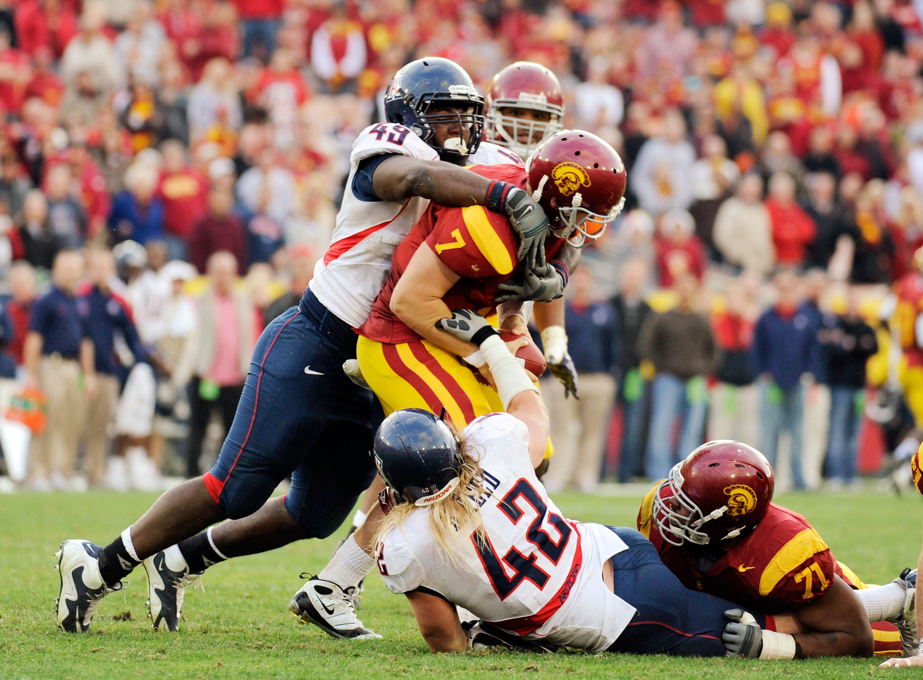 LOS ANGELES, CA - DECEMBER 05: Quarterback Matt Barkley #7 of the USC Trojans is sacked by Earl Mitchell #49 and Brooks Reed #42 of the Arizona Wildcats during the fourth quarter of the NCAA college football game at the Los Angeles Coliseum on December 5 LOS ANGELES, CA - DECEMBER 05: Quarterback Matt Barkley #7 of the USC Trojans is sacked by Earl Mitchell #49 and Brooks Reed #42 of the Arizona Wildcats during the fourth quarter of the NCAA college football game at the Los Angeles Coliseum on December 5