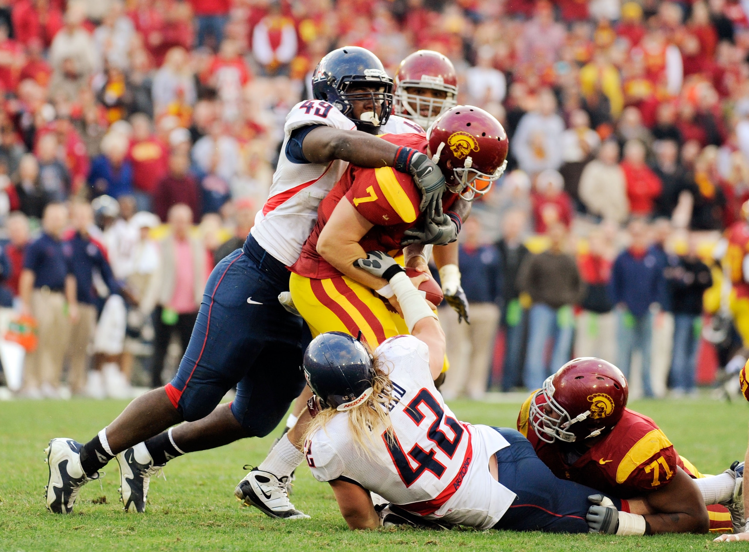 LOS ANGELES, CA - DECEMBER 05:  Quarterback Matt Barkley #7 of the USC Trojans is sacked by Earl Mitchell #49 and Brooks Reed #42 of the Arizona Wildcats during the fourth quarter of the NCAA college football game at the Los Angeles Coliseum on December 5