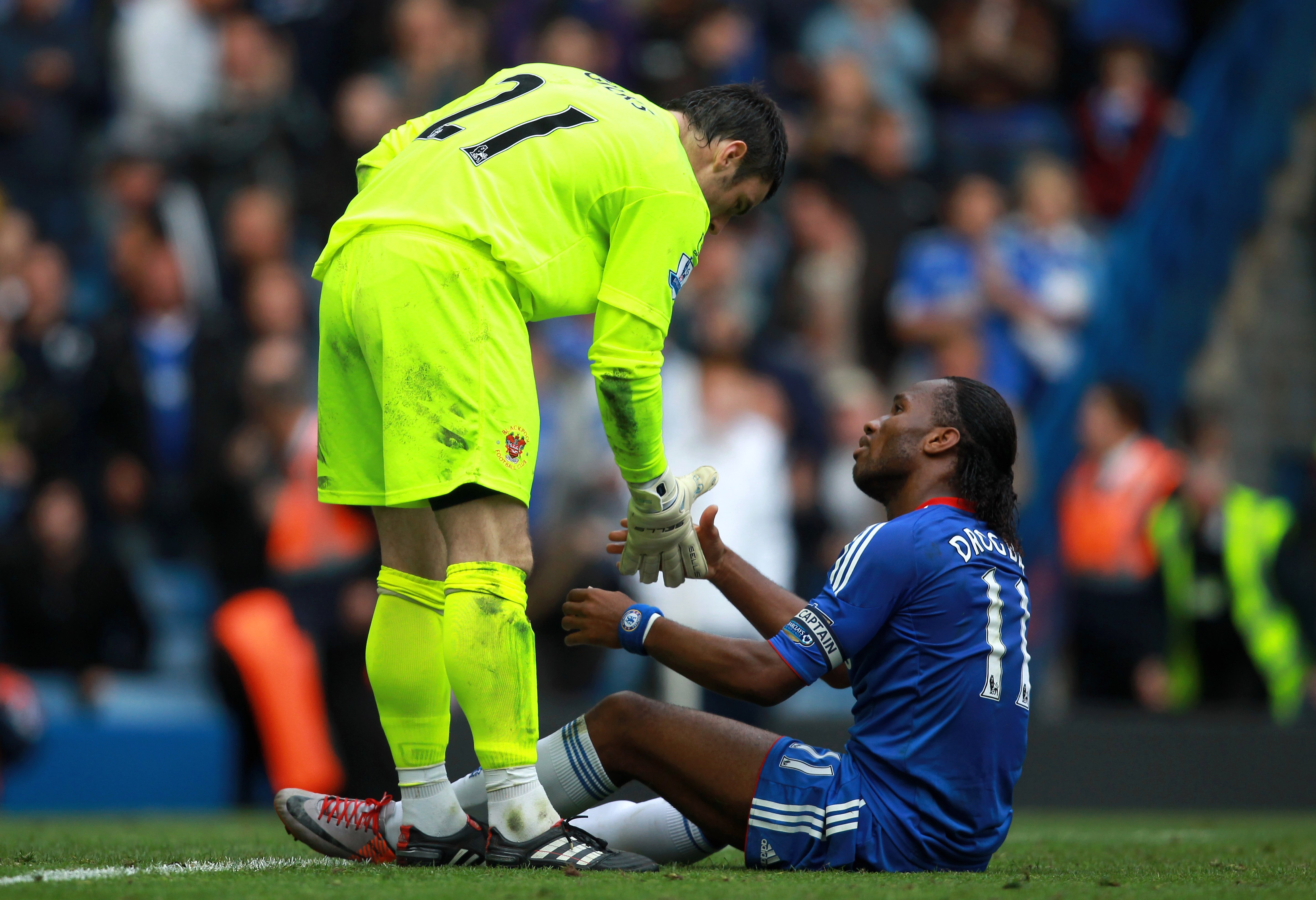LONDON, ENGLAND - SEPTEMBER 19:  Didier Drogba of Chelsea is helped to his feet by goalkeeper Matthew Gilks of Blackpool during the Barclays Premier League match between Chelsea and Blackpool at Stamford Bridge on September 19, 2010 in London, England.  (