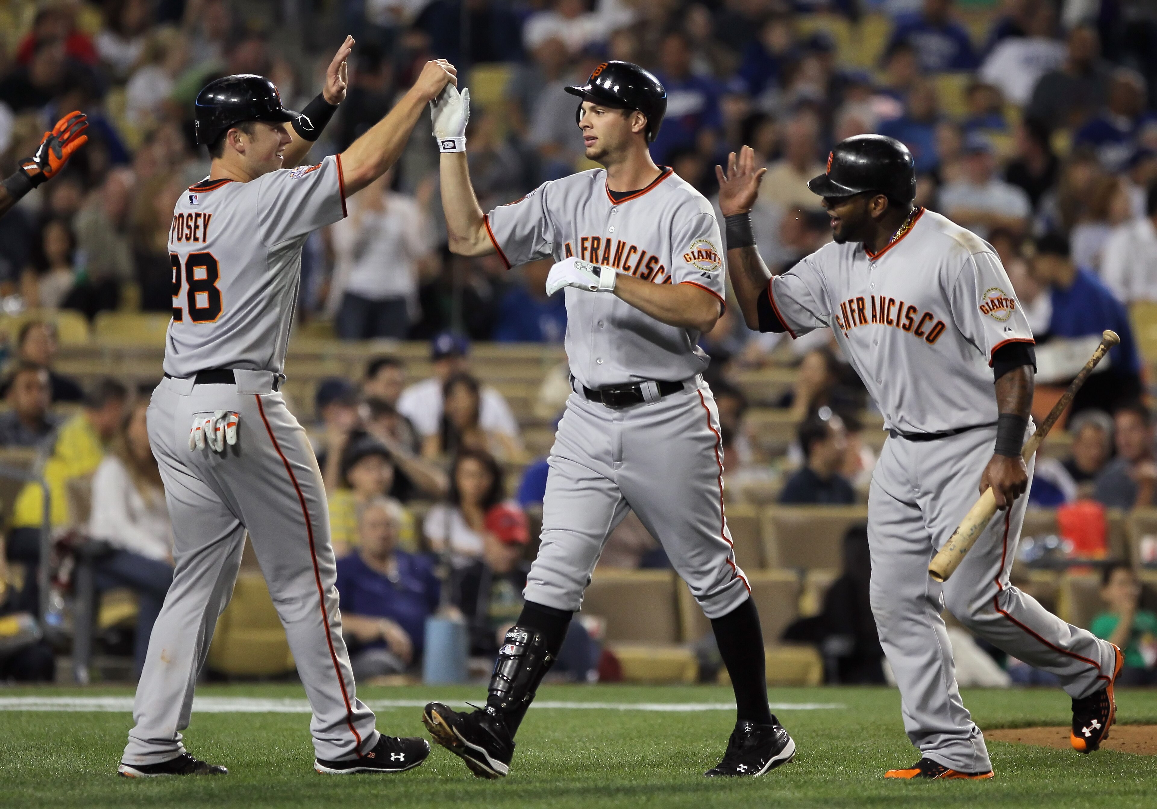 LOS ANGELES, CA - APRIL 01:  Brandon Belt (center) #9 of the San Francisco Giants is congratulated by Buster Posey (L) #28 and Pablo Sandoval (R) #48 after hitting a three-run homerun against the Los Angeles Dodgers in the fourth inning at Dodger Stadium