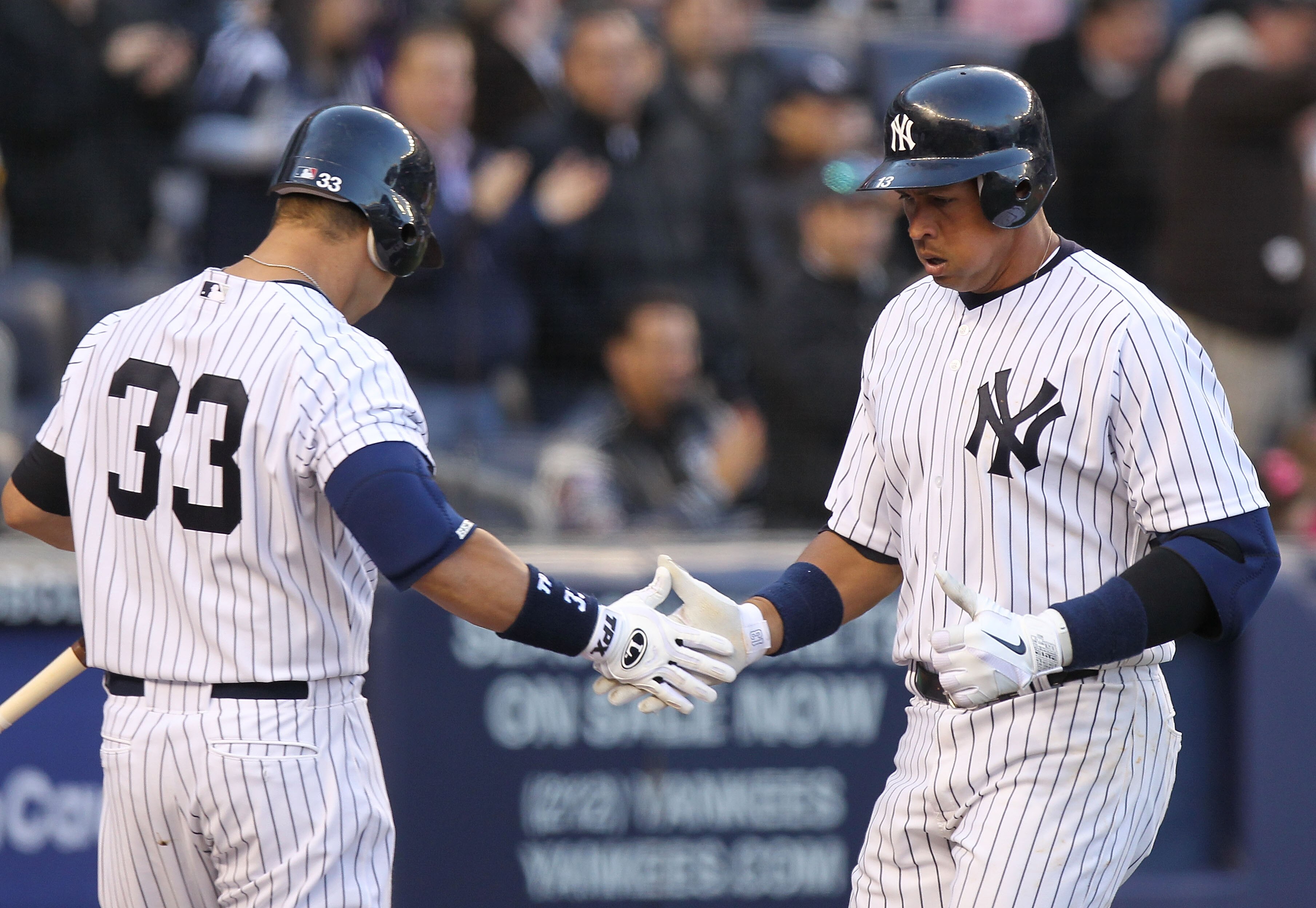 NEW YORK, NY - APRIL 02:  Alex Rodriguez #13 of the New York Yankees celebrates his solo homerun with teammate Nick Swisher #33 against the Detroit Tigers at Yankee Stadium on April 2, 2011 in the Bronx borough of New York City.  (Photo by Nick Laham/Gett