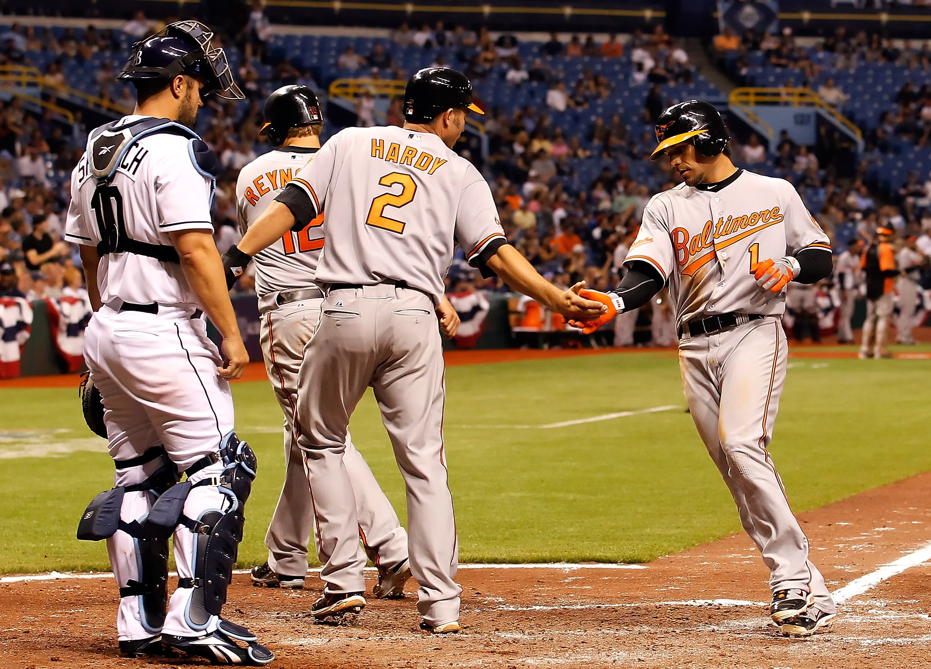 ST. PETERSBURG, FL - APRIL 02:  Infielder Brian Roberts #1 of the Baltimore Orioles is congratulated by J.J. Hardy #2 after this three run home run against the Tampa Bay Rays during the game at Tropicana Field on April 2, 2011 in St. Petersburg, Florida.