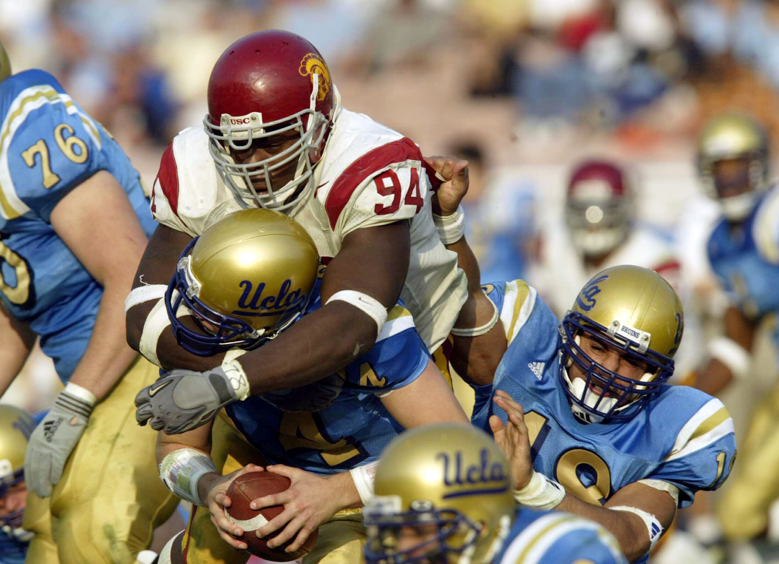 PASADENA, CA - NOVEMBER 23:    Kenech Udeze #94 of USC sacks quarterback Drew Olson of UCLA while Mike Sidman #18 tries to block on November 23, 2002 at the Rose Bowl in Pasadena, California. USC won 52-21. (Photo by Stephen Dunn/Getty Images)