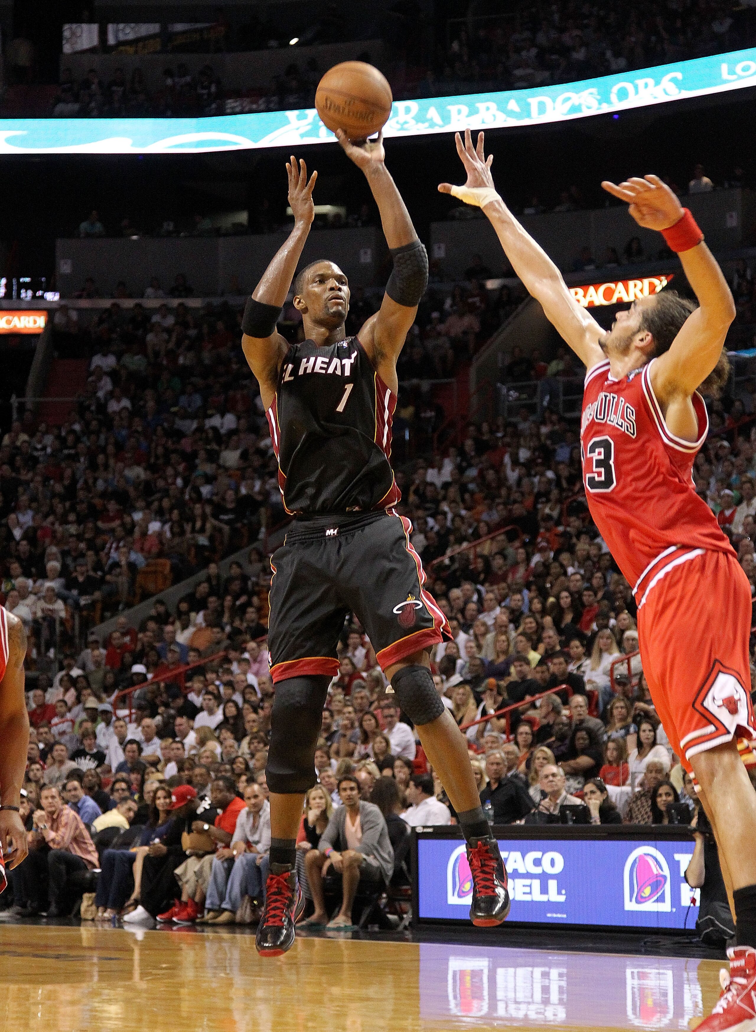 MIAMI, FL - MARCH 06: Chris Bosh #1 of the Miami Heat shoots over Joakim Noah #13 of the Chicago Bulls during a game at American Airlines Arena on March 6, 2011 in Miami, Florida. NOTE TO USER: User expressly acknowledges and agrees that, by downloading a MIAMI, FL - MARCH 06: Chris Bosh #1 of the Miami Heat shoots over Joakim Noah #13 of the Chicago Bulls during a game at American Airlines Arena on March 6, 2011 in Miami, Florida. NOTE TO USER: User expressly acknowledges and agrees that, by downloading a
