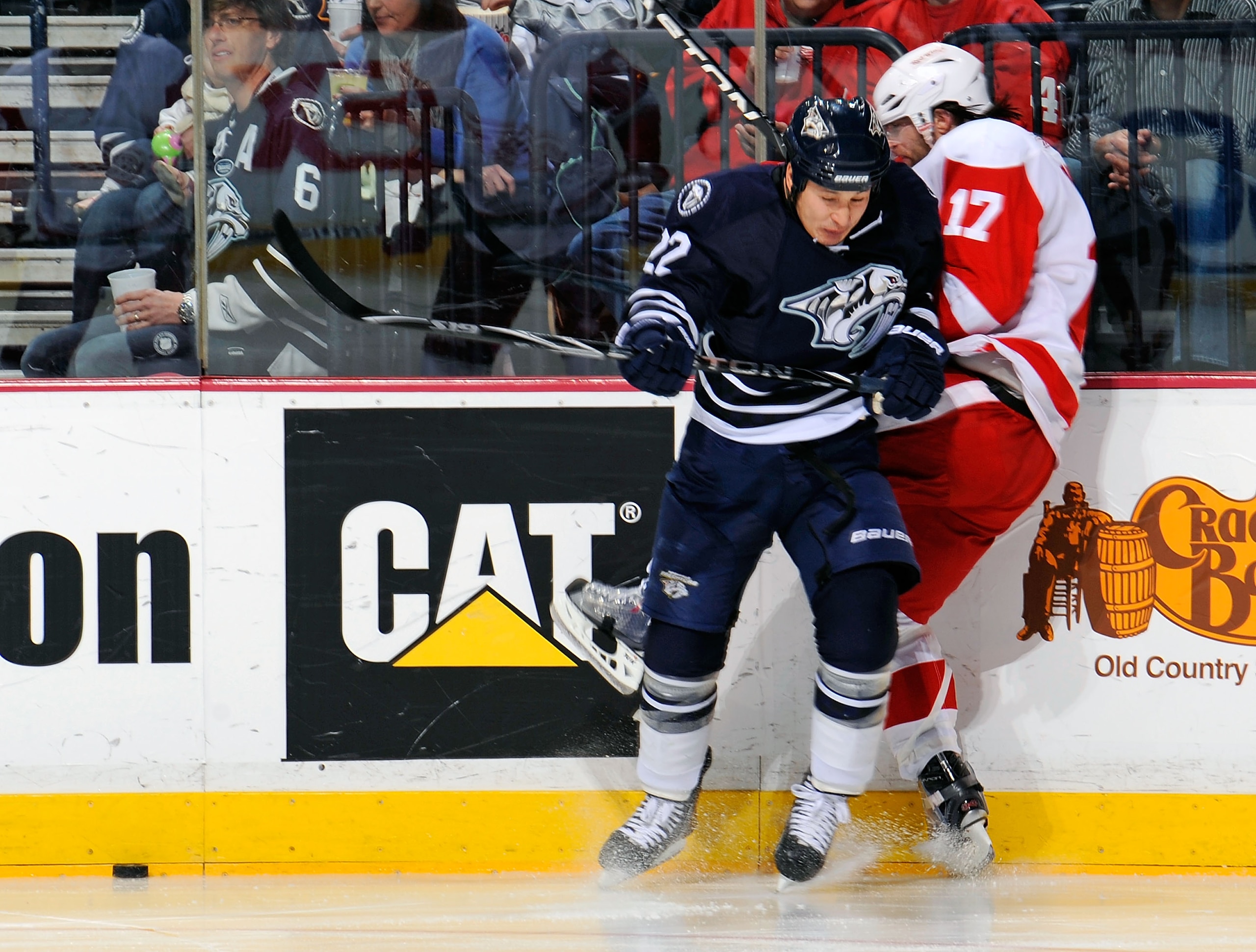 NASHVILLE, TN - MARCH 19:    Jordin Tootoo #22 of the Nashville Predators checks Patrick Eaves #17 of the Detroit Red Wings on March 19, 2011 at the Bridgestone Arena in Nashville, Tennessee.  (Photo by Frederick Breedon/Getty Images)