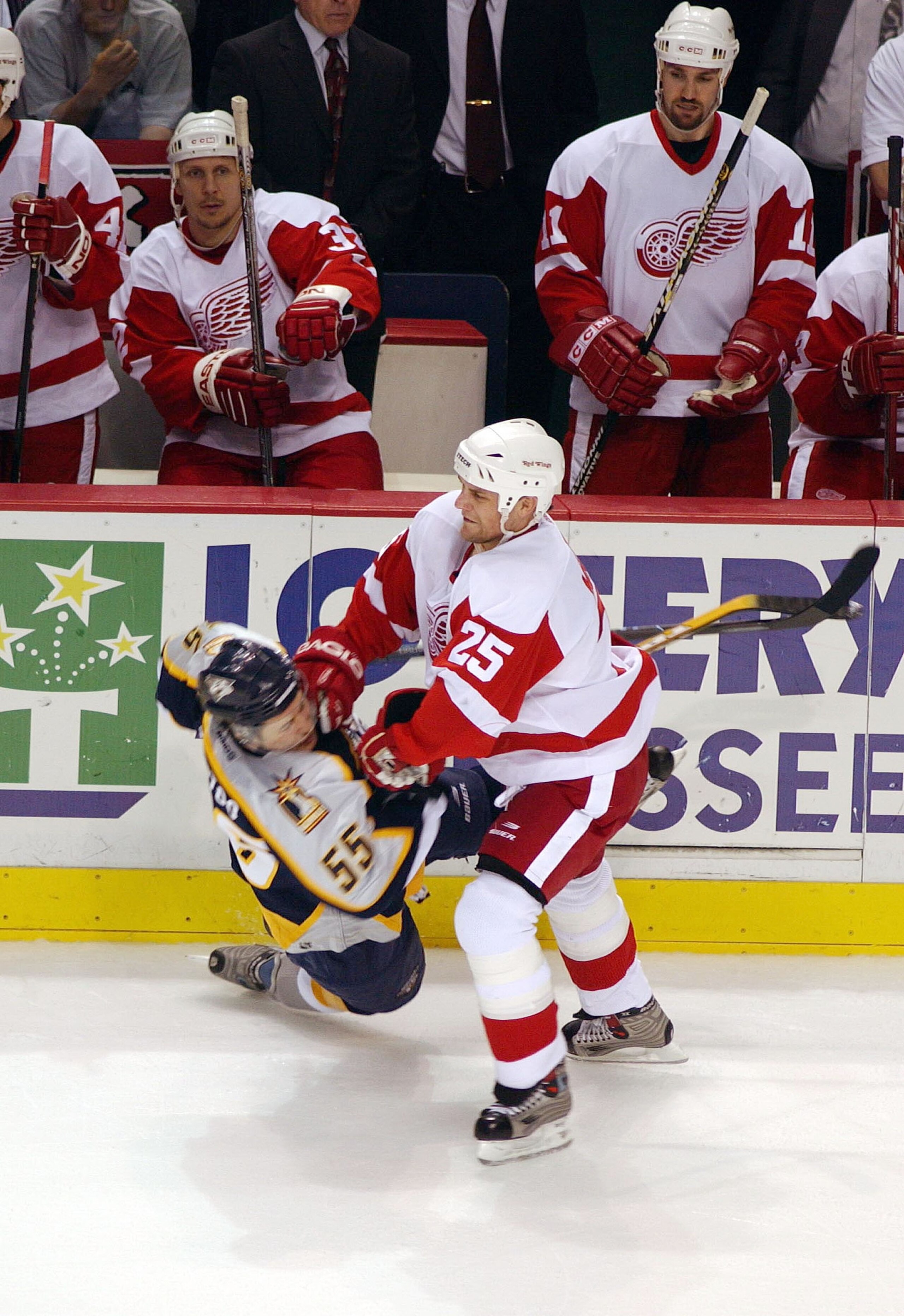 NASHVILLE, TN - APRIL 17:  Darren McCarty #25 of the Detroit Red Wings checks Jordin Tootoo #55 of the Nashville Predators in the first round of the Stanley Cup playoffs on April 17, 2004 at Gaylord Entertainment Center in Nashville, Tennessee.  (Photo by
