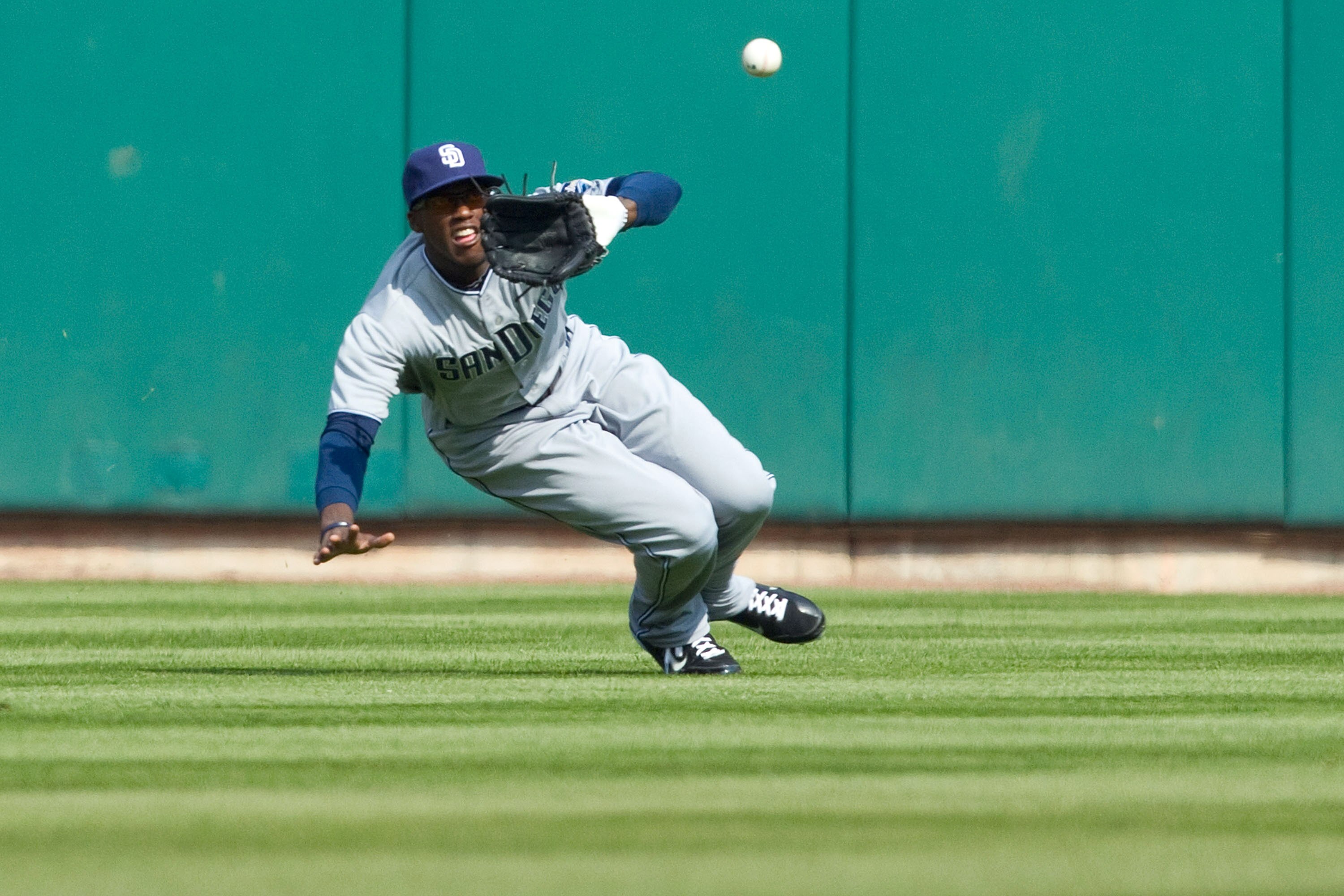 ST. LOUIS, MO - MARCH 31: Cameron Maybin #24 of the San Diego Padres makes a sliding catch against the St. Louis Cardinals on opening day at Busch Stadium on March 31, 2011 in St. Louis, Missouri.  (Photo by Dilip Vishwanat/Getty Images)