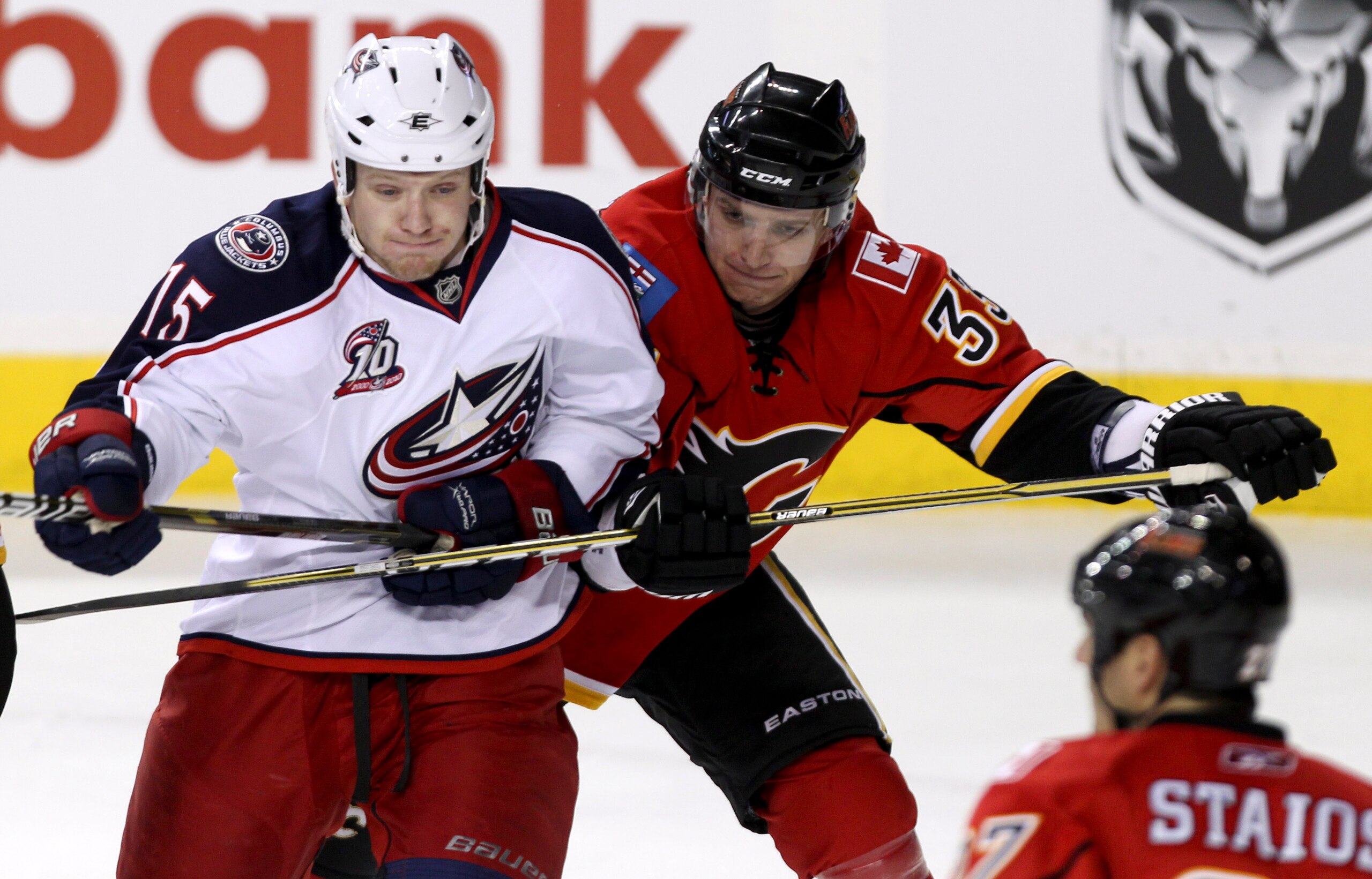 CALGARY, AB - MARCH 4:  Anton Babchuk #33 of the Calgary Flames gets his stick around Derek Dorsett #15 of the Columbus Blue Jackets in the second period of NHL action on March 4, 2011 at the Scotiabank Saddledome in Calgary, Alberta, Canada. (Photo by Mi