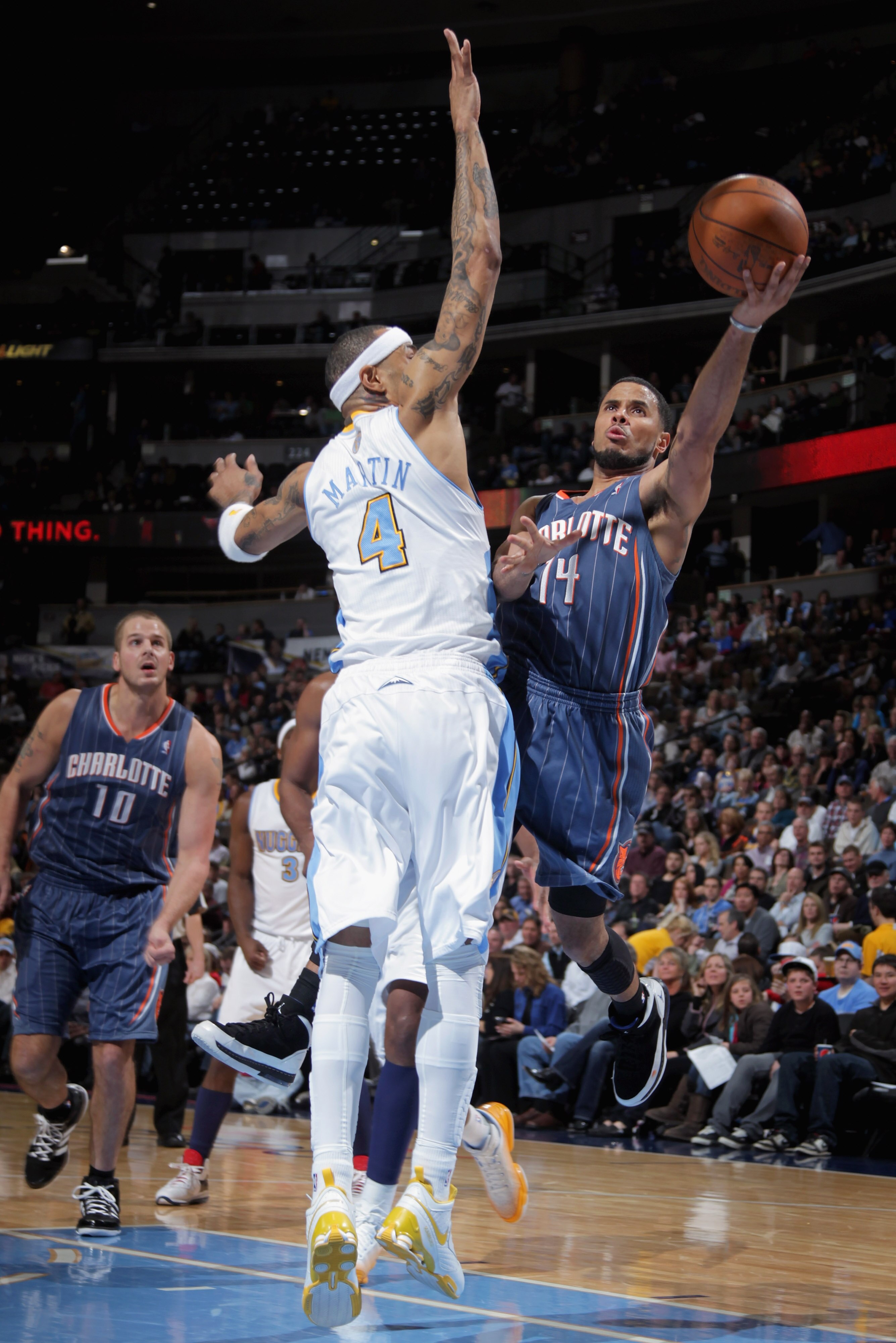 DENVER, CO - MARCH 02:  D.J. Augustin #14 of the Charlotte Bobcats puts up a shot against Kenyon Martin #4 of the Denver Nuggets at the Pepsi Center on March 2, 2011 in Denver, Colorado. The Nuggets defeated the Bobcats 120-80.NOTE TO USER: User expressly
