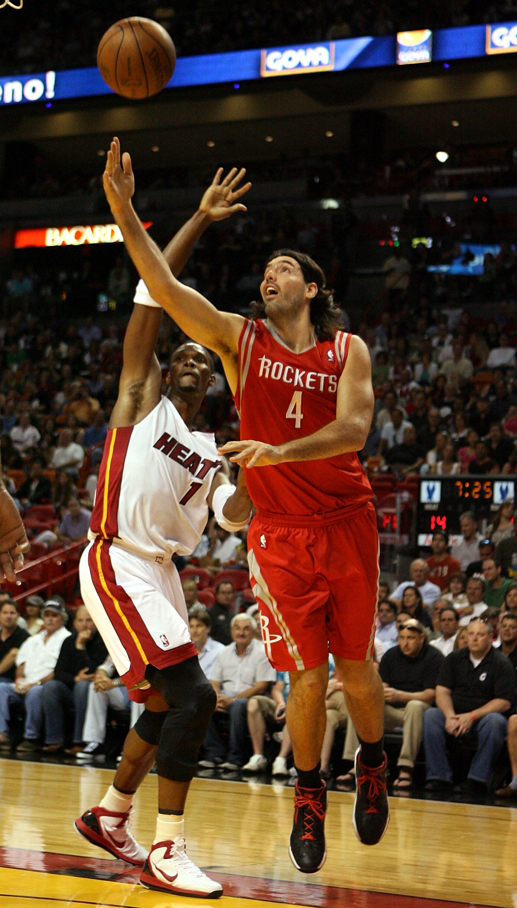 MIAMI, FL - MARCH 27:  Forward Chris Bosh #1 of the Miami Heat defends against Forward Luis Scola #4 of the Houston Rockets at American Airlines Arena on March 27, 2011 in Miami, Florida. NOTE TO USER: User expressly acknowledges and agrees that, by downl