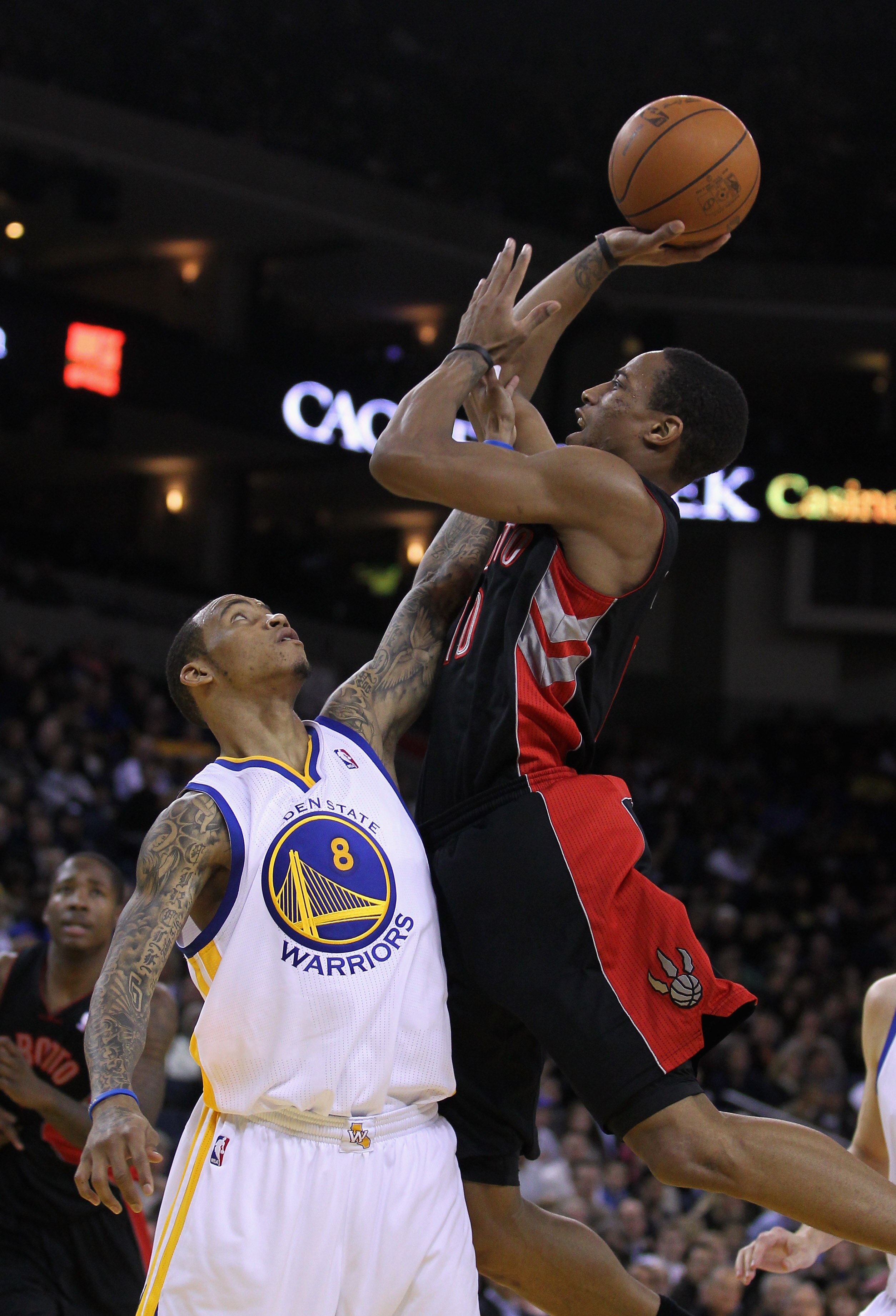 OAKLAND, CA - MARCH 25: DeMar DeRozan #10 of the Toronto Raptors shoots over Monta Ellis #8 of the Golden State Warriors at Oracle Arena on March 25, 2011 in Oakland, California. NOTE TO USER: User expressly acknowledges and agrees that, by downloading an