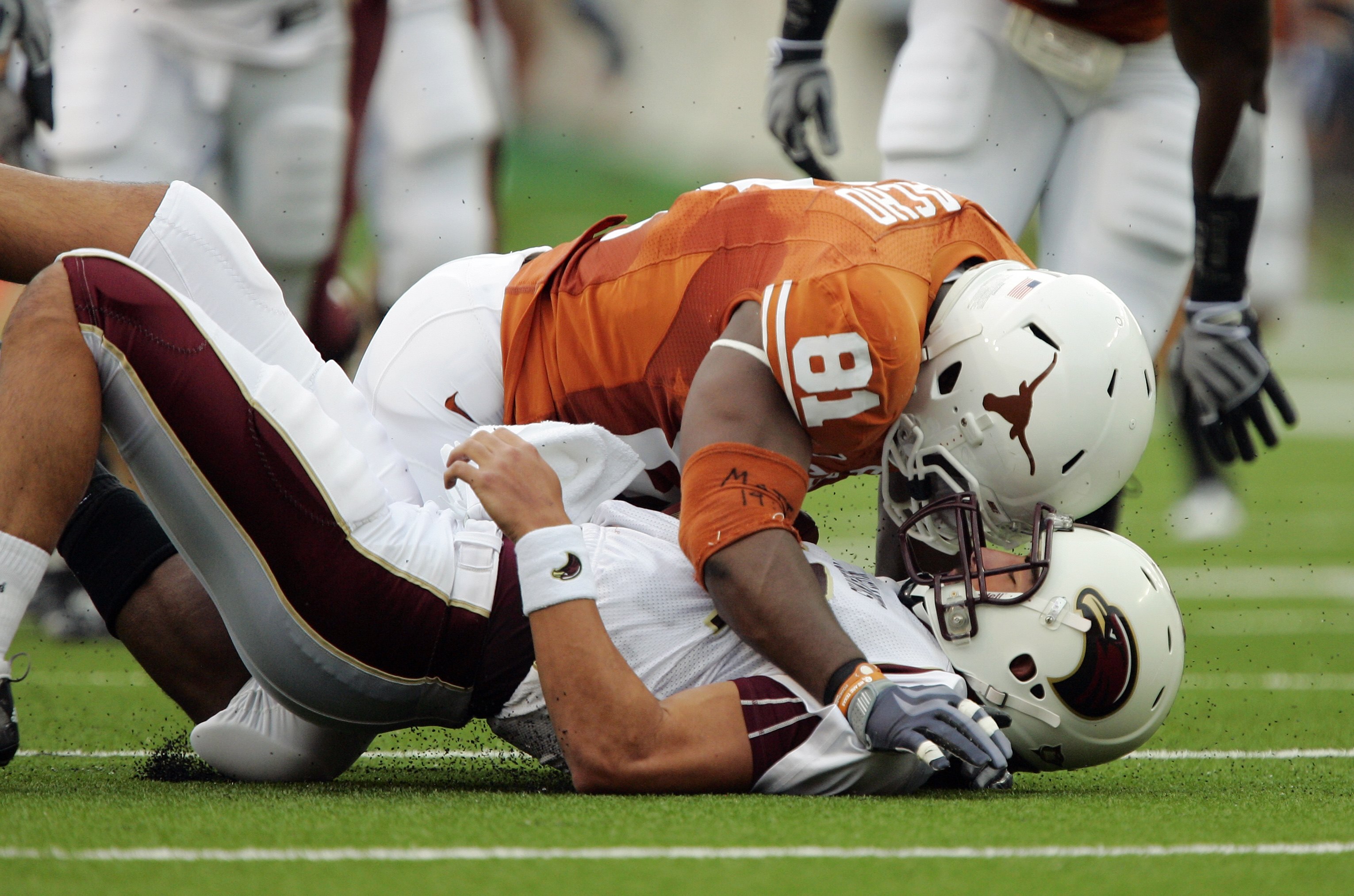 AUSTIN, TX - SEPTEMBER 5:  Defensive end Sam Acho #81 of the Texas Longhorns falls on quarterback Trey Revell #12 of the Louisiana Monroe Warhawks after knocking the ball away from Revell during their game on September 5, 2009 at Darrell K Royal-Texas Mem