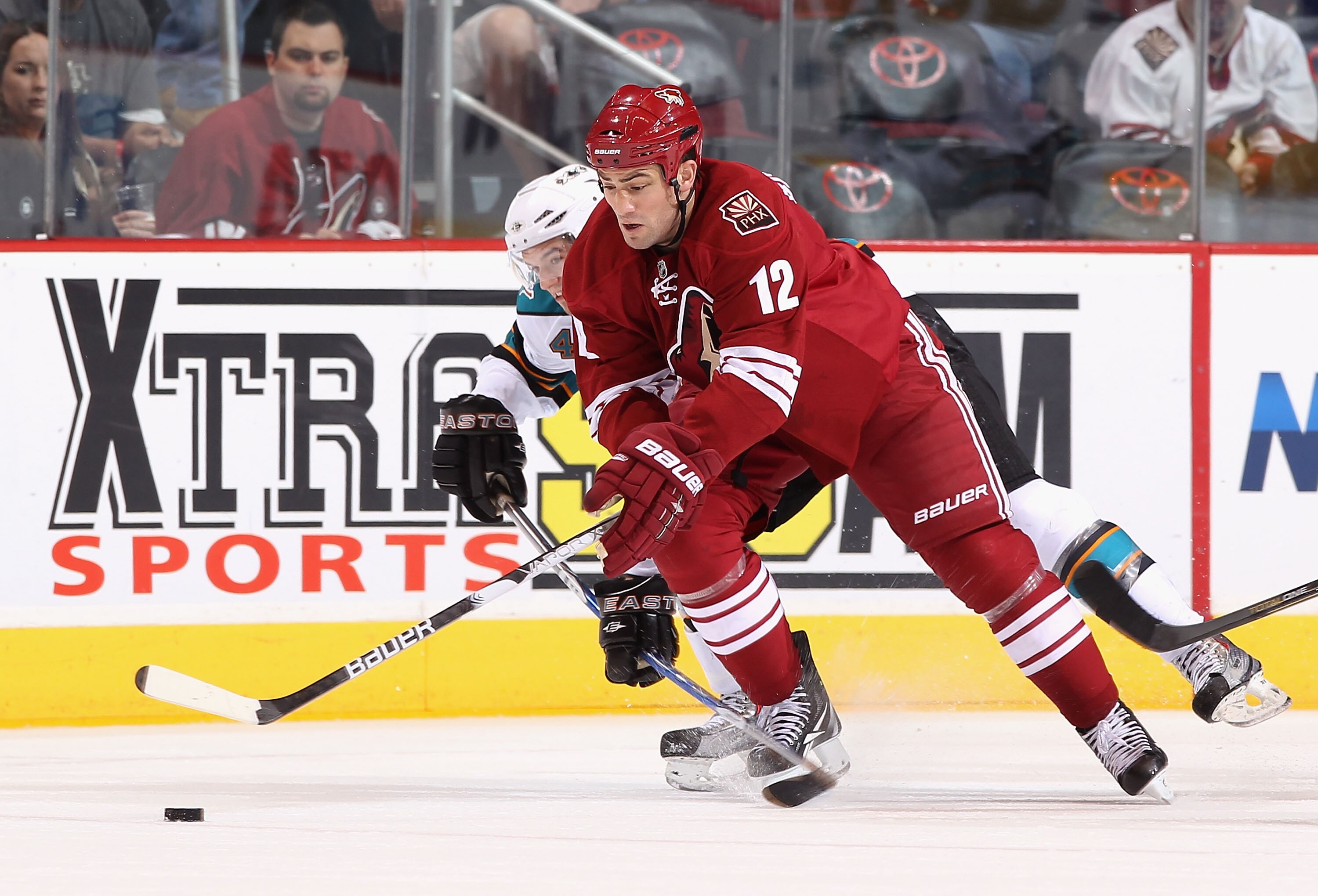 GLENDALE, AZ - MARCH 26:  Paul Bissonnette #12 of the Phoenix Coyotes battles for the puck with Marc-Edouard Vlasic #44 of the San Jose Sharks during the NHL game at Jobing.com Arena on March 26, 2011 in Glendale, Arizona. The Sharks defeated the Coyotes