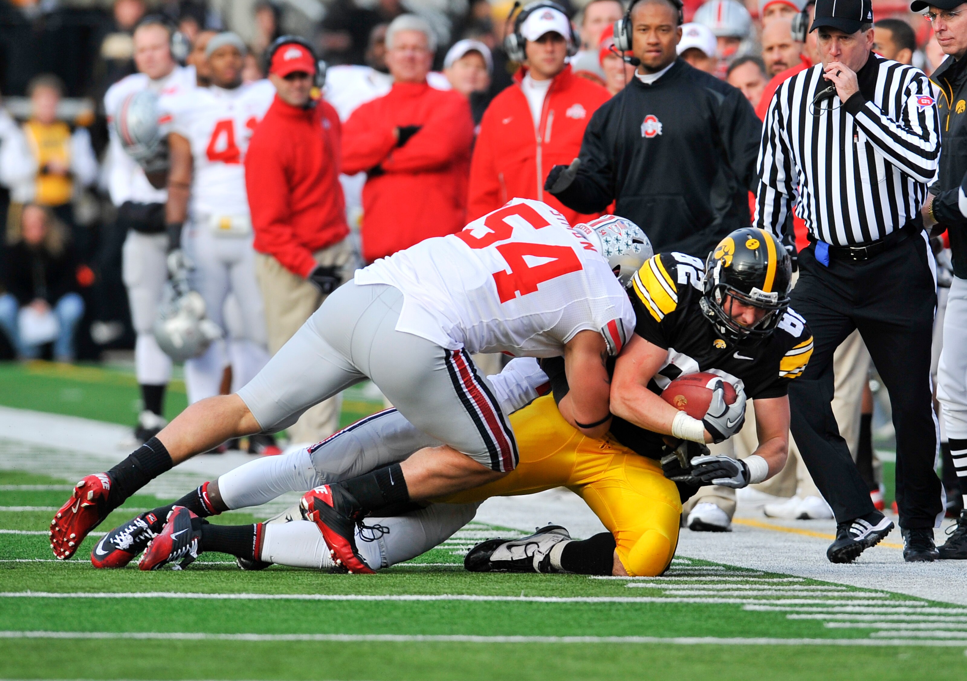 IOWA CITY, IA - NOVEMBER 20:  Tight end Allen Reisner #82 of the University of Iowa Hawkeyes is tackled by defensive tackle John Simon #54 of the Ohio State Buckeyes during the first half of play at Kinnick Stadium on November 20, 2010 in Iowa City, Iowa.