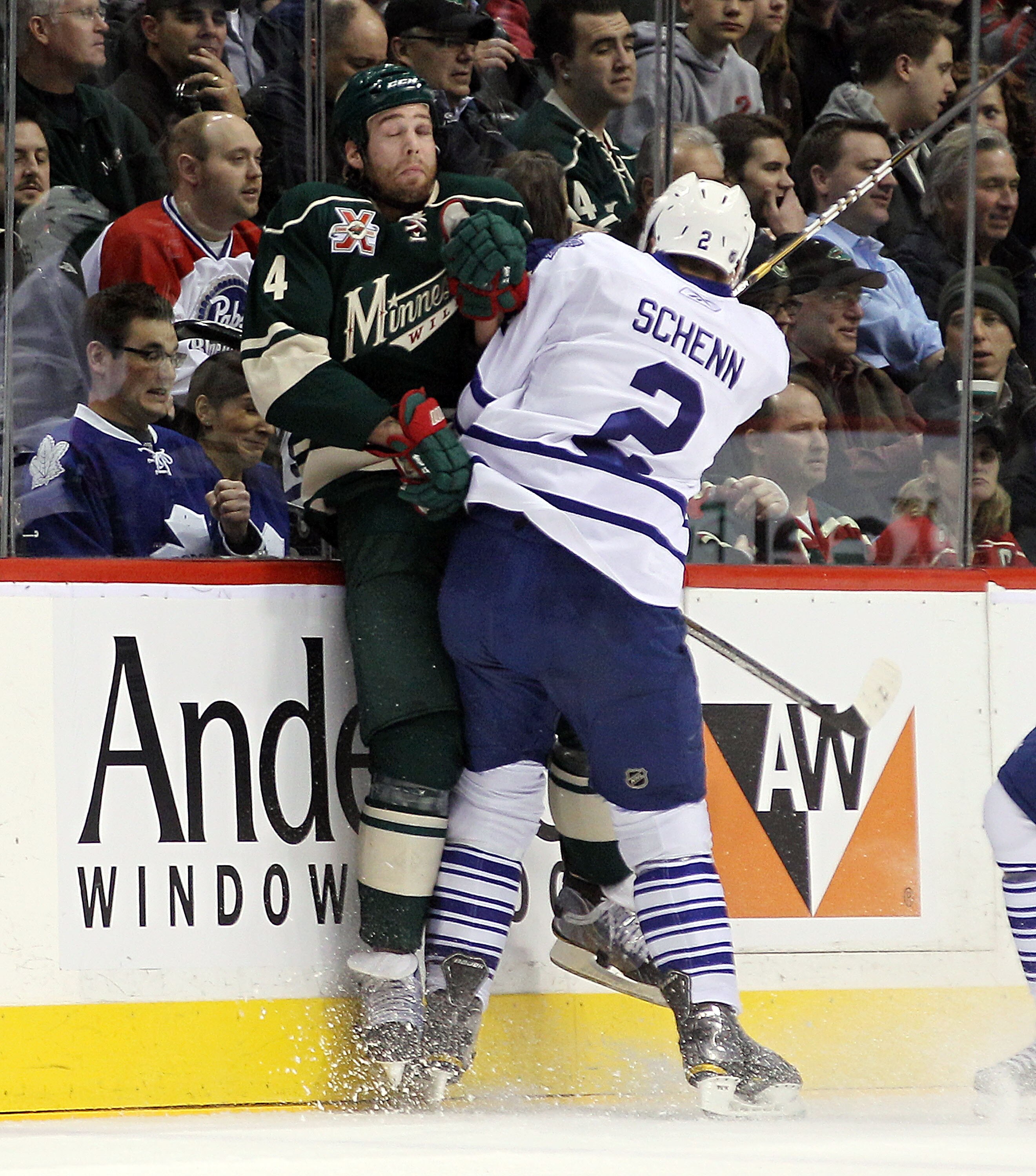 ST PAUL, MN - MARCH 22: Luke Schenn #2 of the Toronto Maple Leafs hits Clayton Stoner #4 of the Minnesota Wild into the boards at the Xcel Energy Center on March 22, 2011 in St Paul, Minnesota.  (Photo by Bruce Bennett/Getty Images)