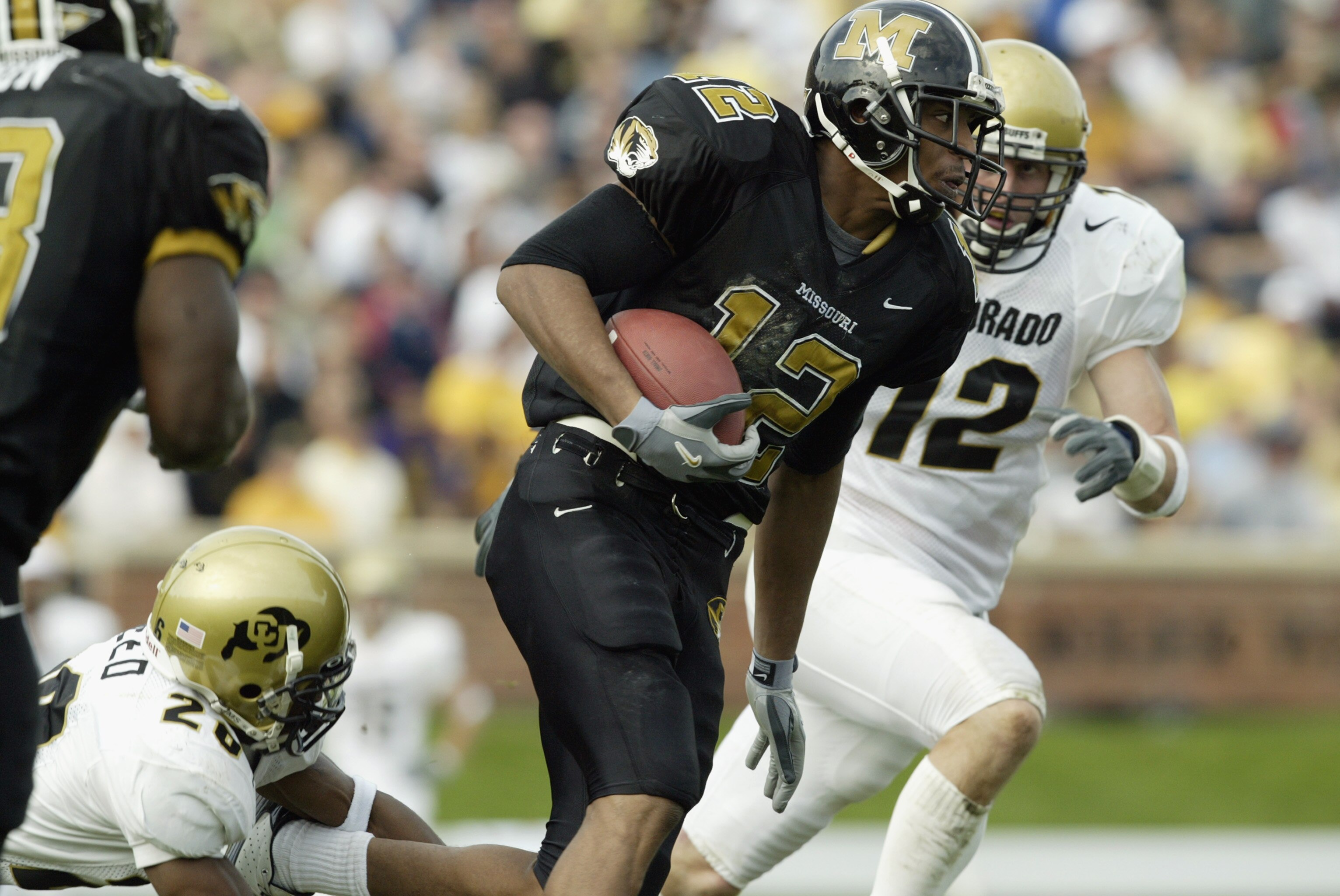 COLUMBIA, MO - NOVEMBER 9:  Justin Gage #12 of the Missouri Tigers carries the ball as Clyde Surrell #20 and Kory Mossoni #12 of the Colorado Buffaloes chase him during the Big 12 Conference football game at Faurot Field on November 9, 2002 in Columbia, M