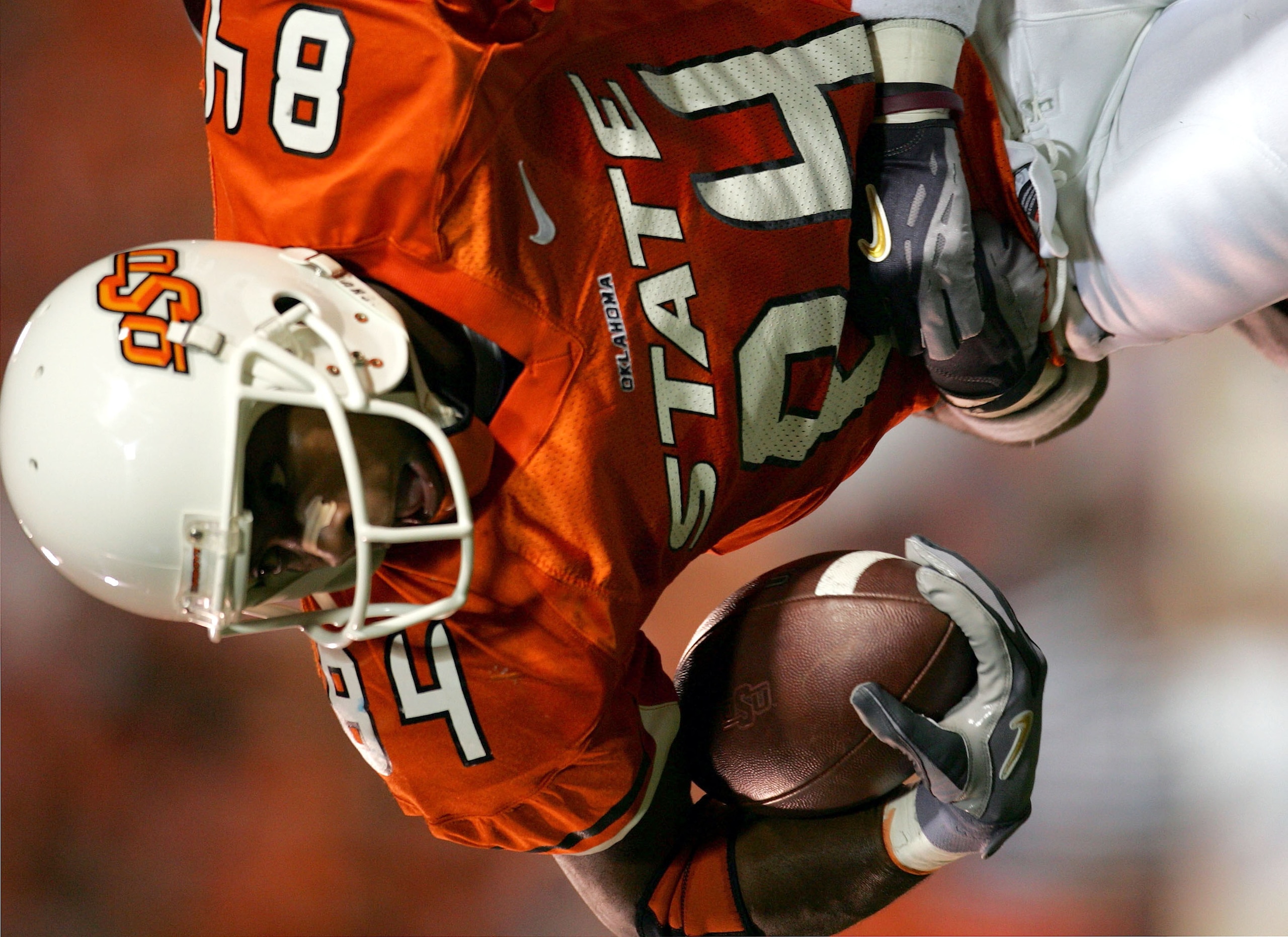 STILLWATER, OKLAHOMA - OCTOBER 16:  D'Juan Woods #84 of Oklahoma State is held from behind by the Texas A & M  defense in the second quarter at Boone Pickens Stadium on October 16, 2004 in Stillwater, Oklahoma. Texas A & M beat Oklahoma State 36-20. (Phot