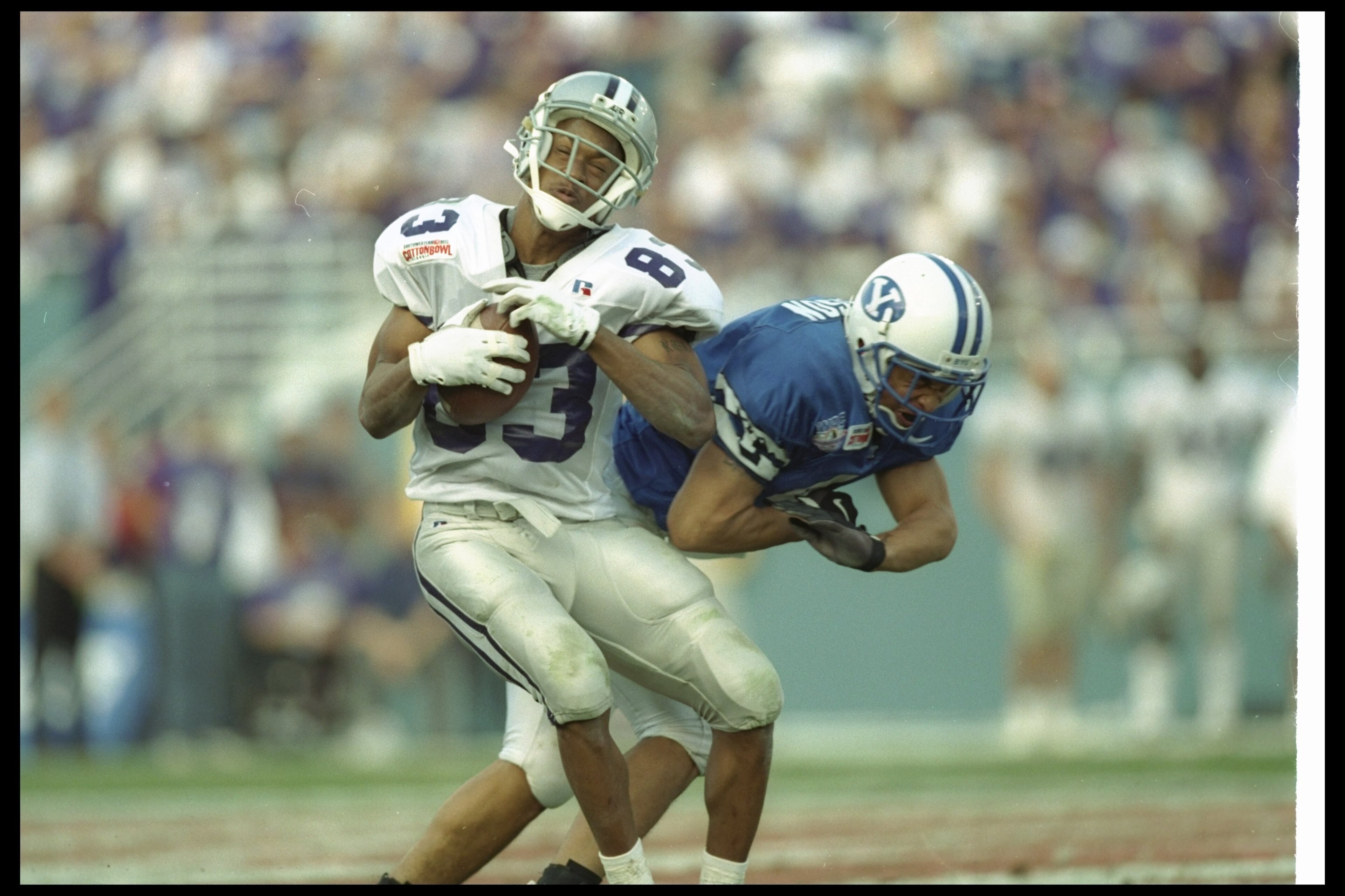 1 Jan 1997:  Wide receiver Kevin Lockett of the Kansas State Wildcats catches the ball as Brigham Young Cougars defensive back Eddie Sampson covers him during the Cotton Bowl at the Cotton Bowl in Dallas, Texas.  BYU won the game, 19-15. Mandatory Credit: