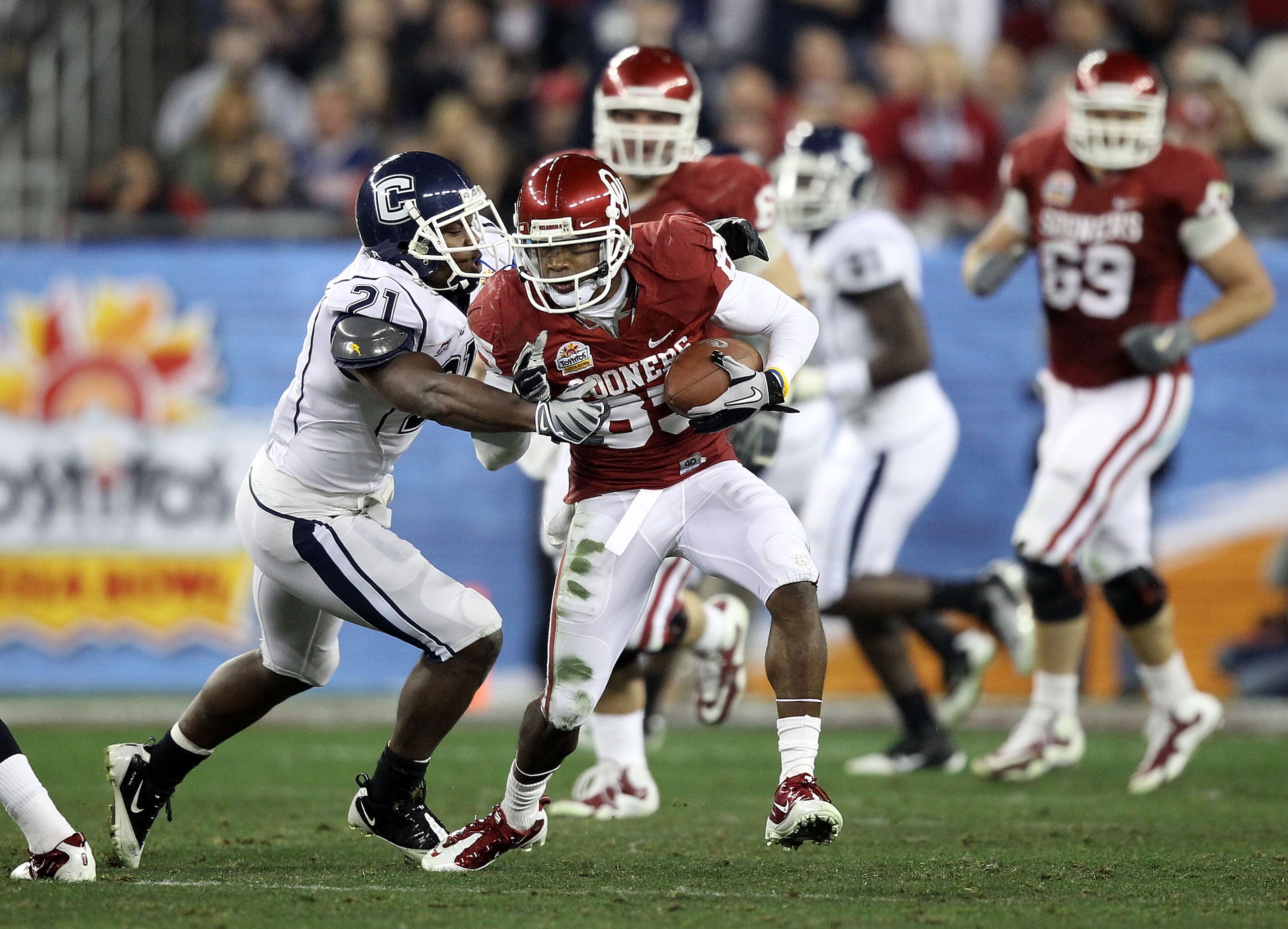 GLENDALE, AZ - JANUARY 01:  Ryan Broyles #85 of the Oklahoma Sooners of the Oklahoma Sooners runs after a catch as Gary Wilburn #21 of the Connecticut Huskies goes for the tackle during the Tostitos Fiesta Bowl at the Universtity of Phoenix Stadium on Jan