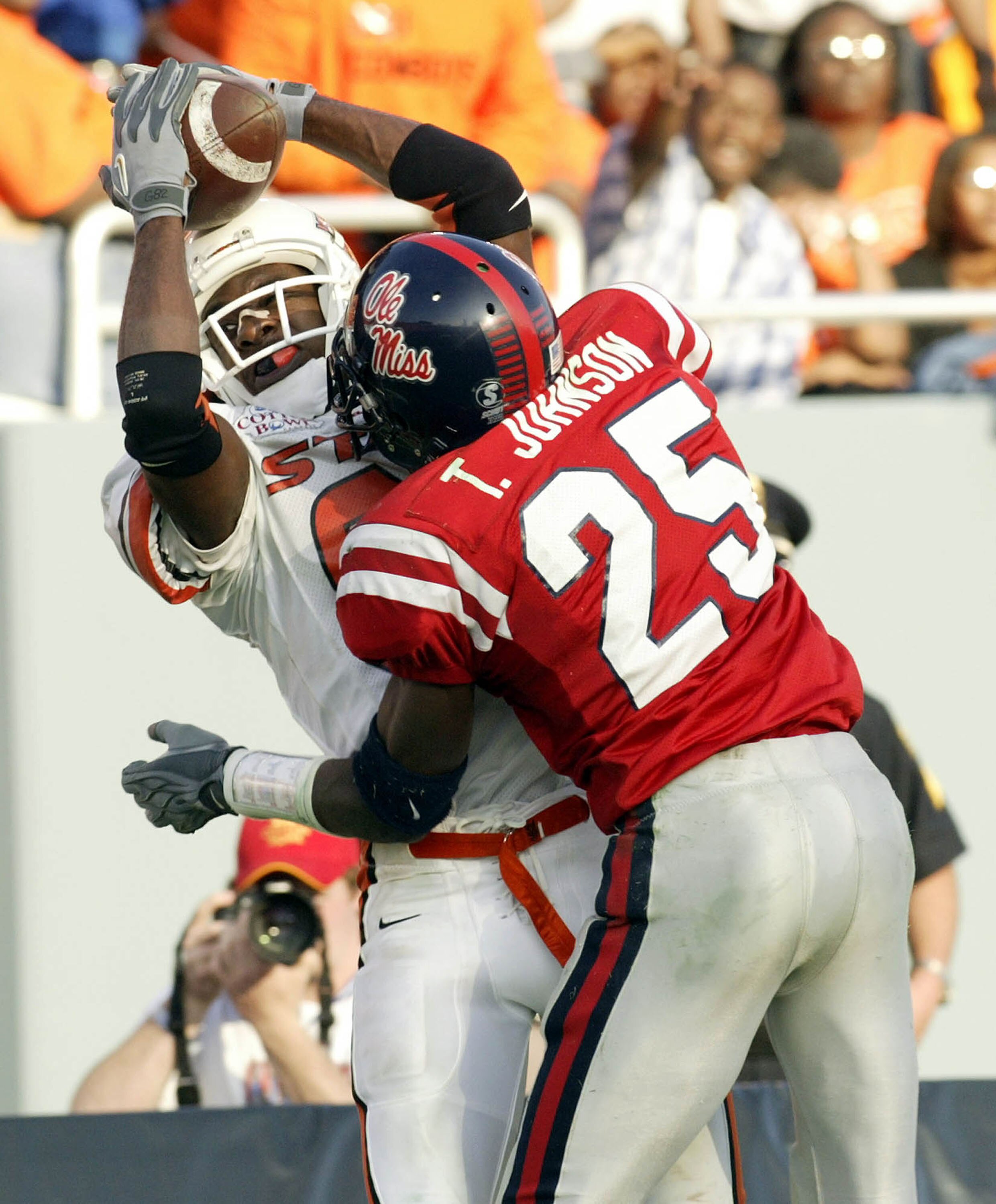DALLAS - JANUARY 2:  Rashaun Woods #82 of the Oklahoma State Cowboys makes a pass reception against Travis Johnson #25 of the Mississippi Rebels during the SBC Cotton Bowl on January 2, 2004 in Dallas, Texas.  (Photo by Ronald Martinez/Getty Images)