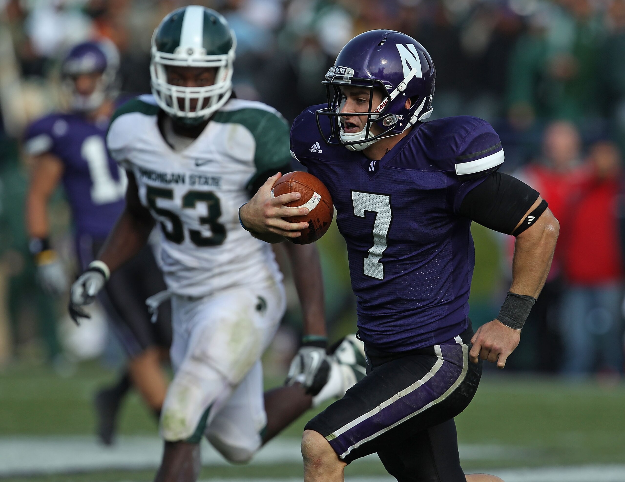 EVANSTON, IL - OCTOBER 23: Dan Persa #7 of the Northwestern Wildcats runs against the Michigan State Spartans pursued by Greg Jones #53 at Ryan Field on October 23, 2010 in Evanston, Illinois. Michigan State defeated Northwestern 35-27. (Photo by Jonatha EVANSTON, IL - OCTOBER 23: Dan Persa #7 of the Northwestern Wildcats runs against the Michigan State Spartans pursued by Greg Jones #53 at Ryan Field on October 23, 2010 in Evanston, Illinois. Michigan State defeated Northwestern 35-27. (Photo by Jonatha