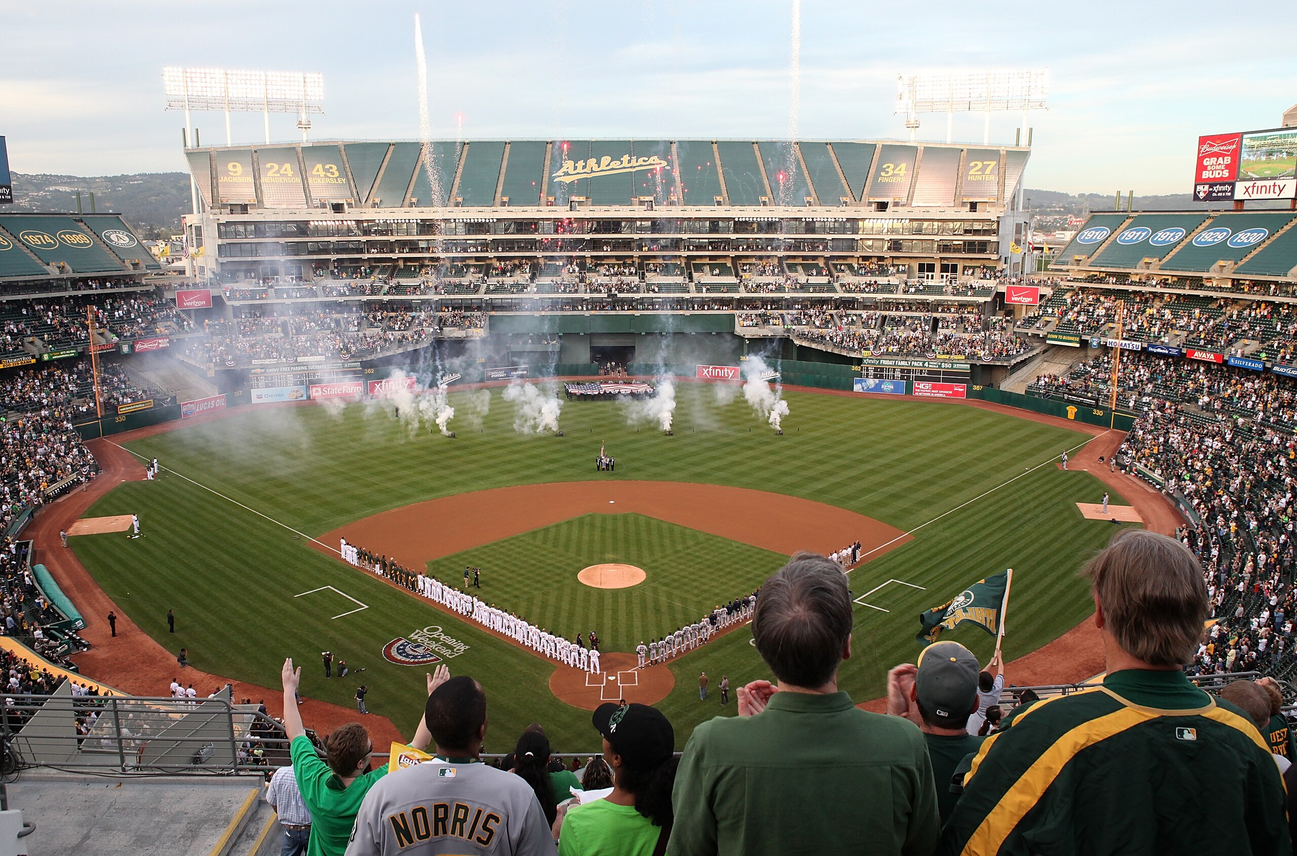 OAKLAND, CA - APRIL 01:  Fans watch the singing of the National Anthem before the start of the Opening Day game with the Oakland Athletics and the Seattle Mariners at the Oakland-Alameda County Coliseum on April 1, 2011 in Oakland, California  (Photo by J