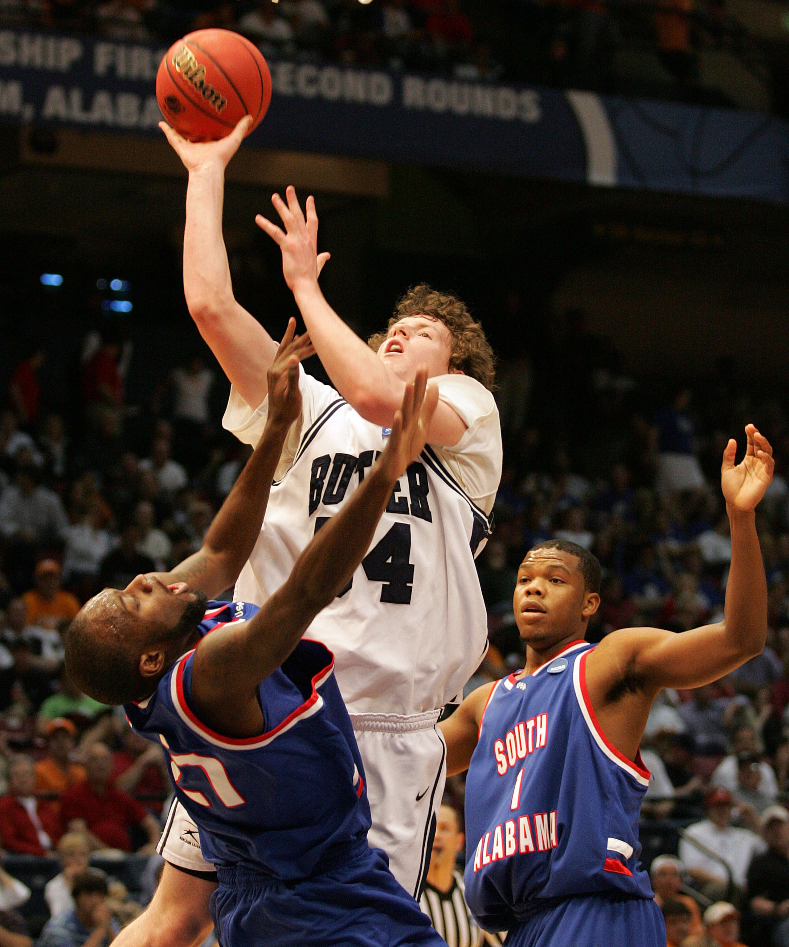 BIRMINGHAM, AL - MARCH 21:  Matt Howard #54 of the Butler Bulldogs shoots over Brandon Davis #21 and DeAndre Coleman #1 of the South Alabama Jaguars during the first round of the South Regional as part of the 2008 NCAA Men's Basketball Tournament at the B
