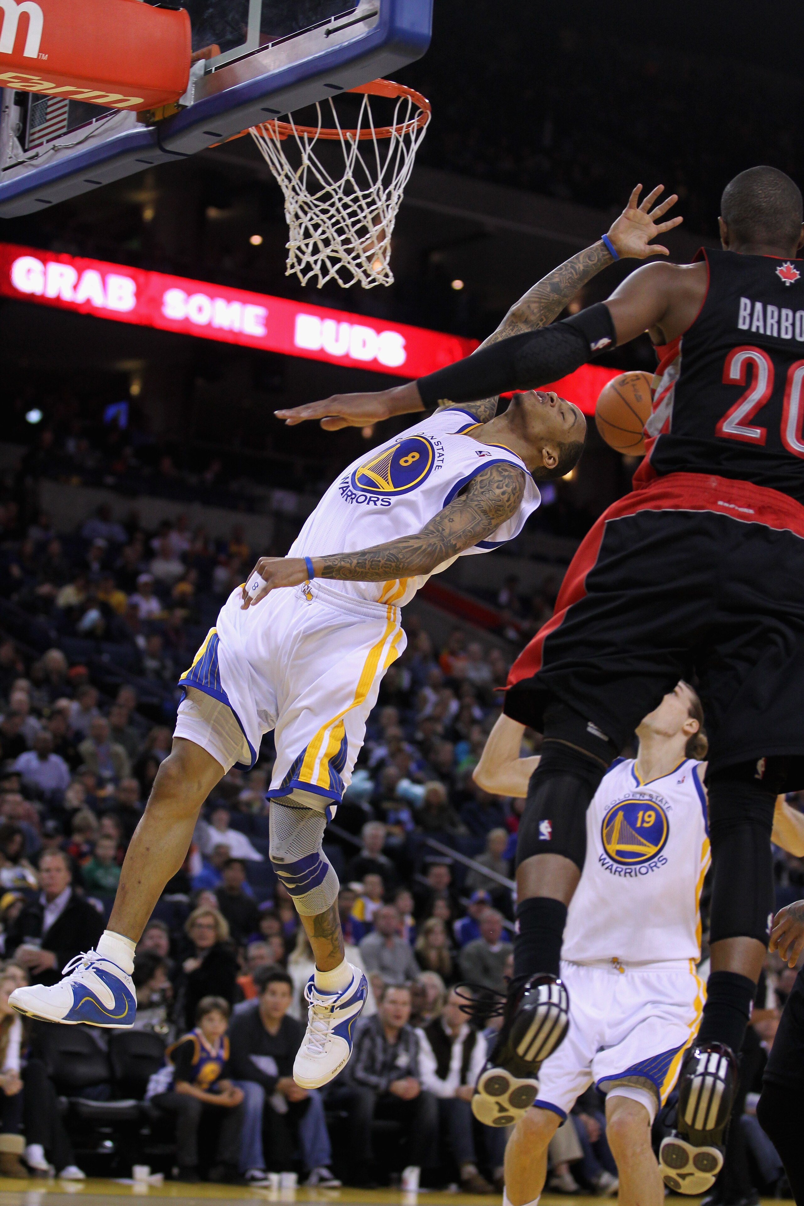 OAKLAND, CA - MARCH 25: Monta Ellis #8 of the Golden State Warriors is fouled by Leandro Barbosa #20 of the Toronto Raptors at Oracle Arena on March 25, 2011 in Oakland, California. NOTE TO USER: User expressly acknowledges and agrees that, by downloading