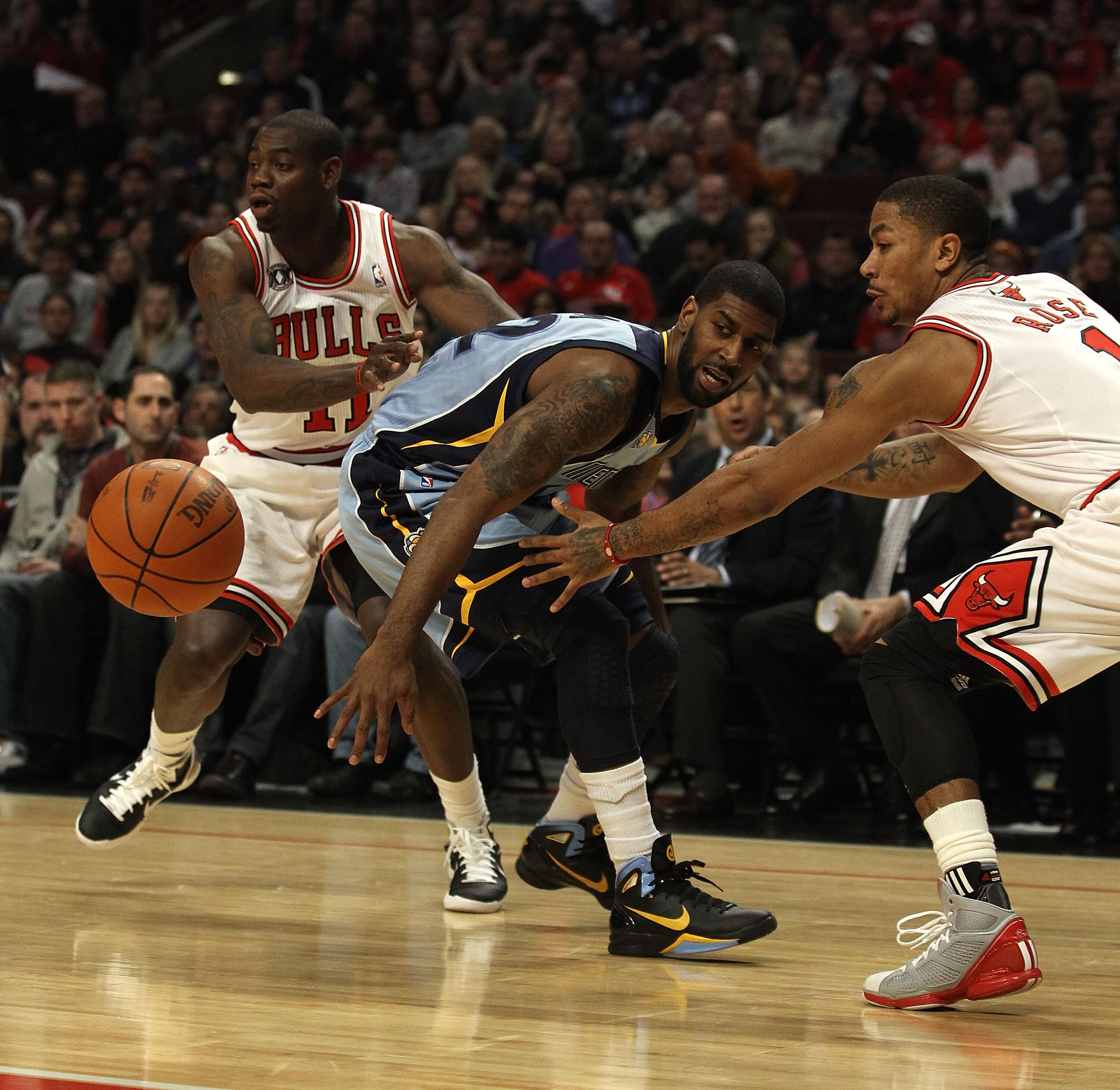 CHICAGO, IL - MARCH 25: O.J. Mayo #32 of the Memphis Grizzlies looses control of the ball under pressure from Ronnie Brewer #11 (L) and Derrick Rose #1 of the Chicago Bulls at the United Center on March 25, 2011 in Chicago, Illinois. The Bulls defeated th