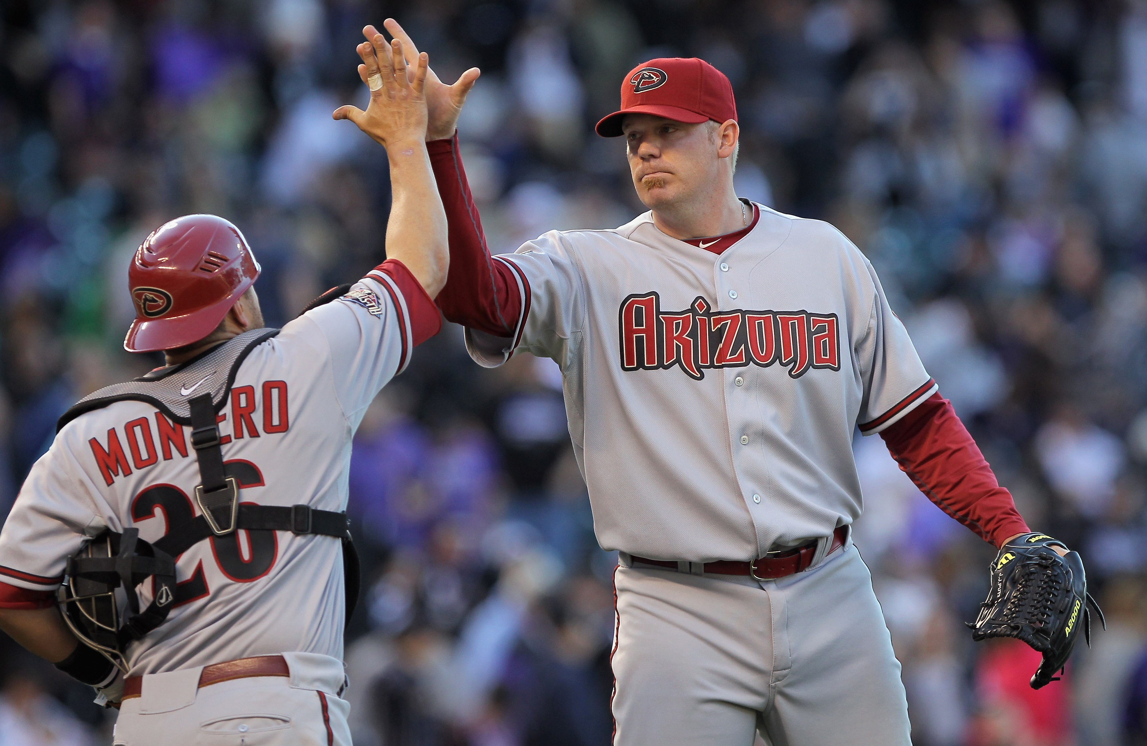 DENVER, CO - APRIL 01:  Pitcher J.J. Putz #40 of the Arizona Diamondbacks and catcher Miguel Montero #26 of the Arizona Diamondbacks celebrate their victory over the Colorado Rockies during Opening Day at Coors Field on April 1, 2011 in Denver, Colorado.