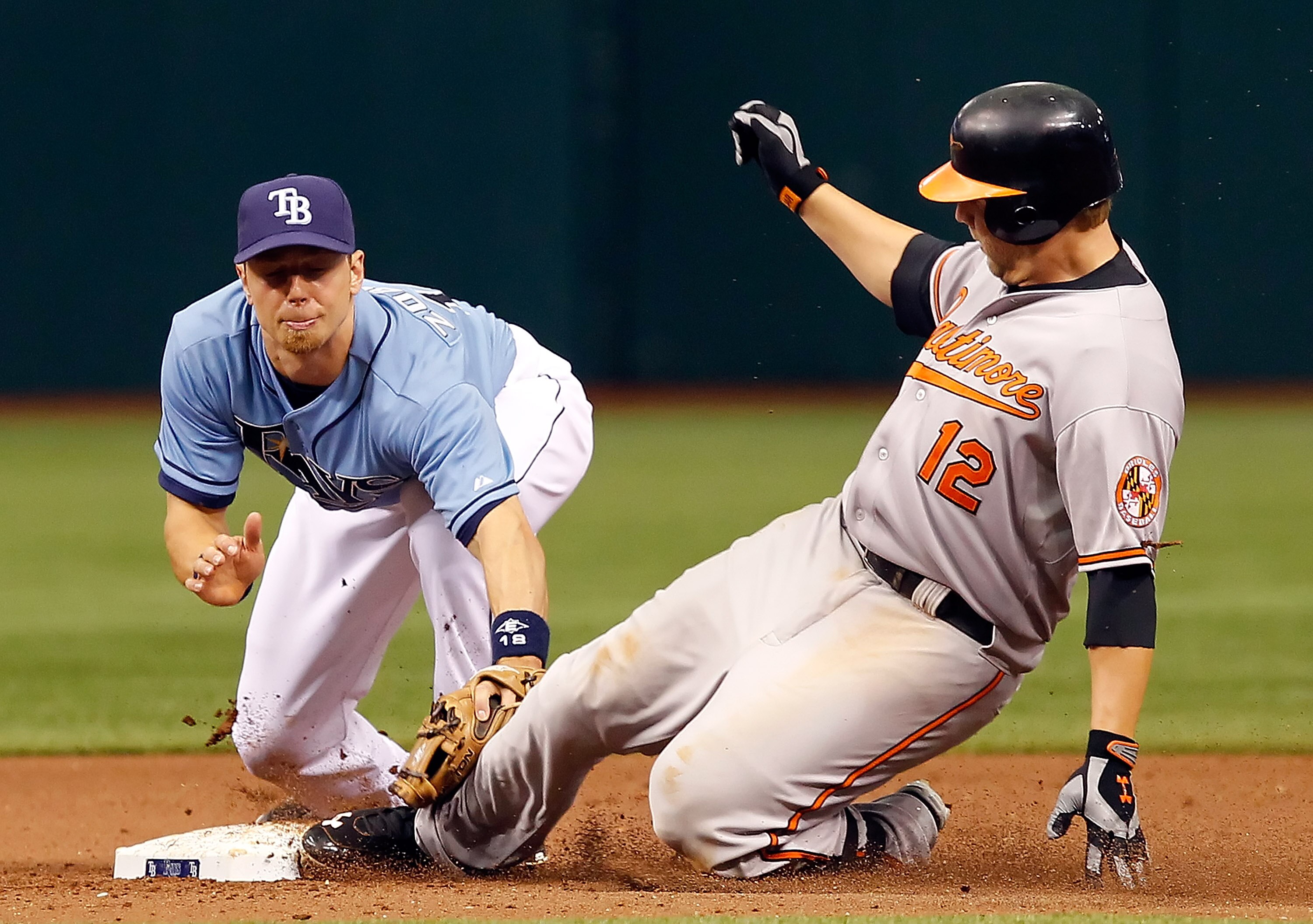 ST. PETERSBURG, FL - APRIL 03:  Infielder Ben Zobrist #18 of the Tampa Bay Rays is late with the tag on Mark Reynolds #12 of the Baltimore Orioles during the game at Tropicana Field on April 3, 2011 in St. Petersburg, Florida.  (Photo by J. Meric/Getty Im